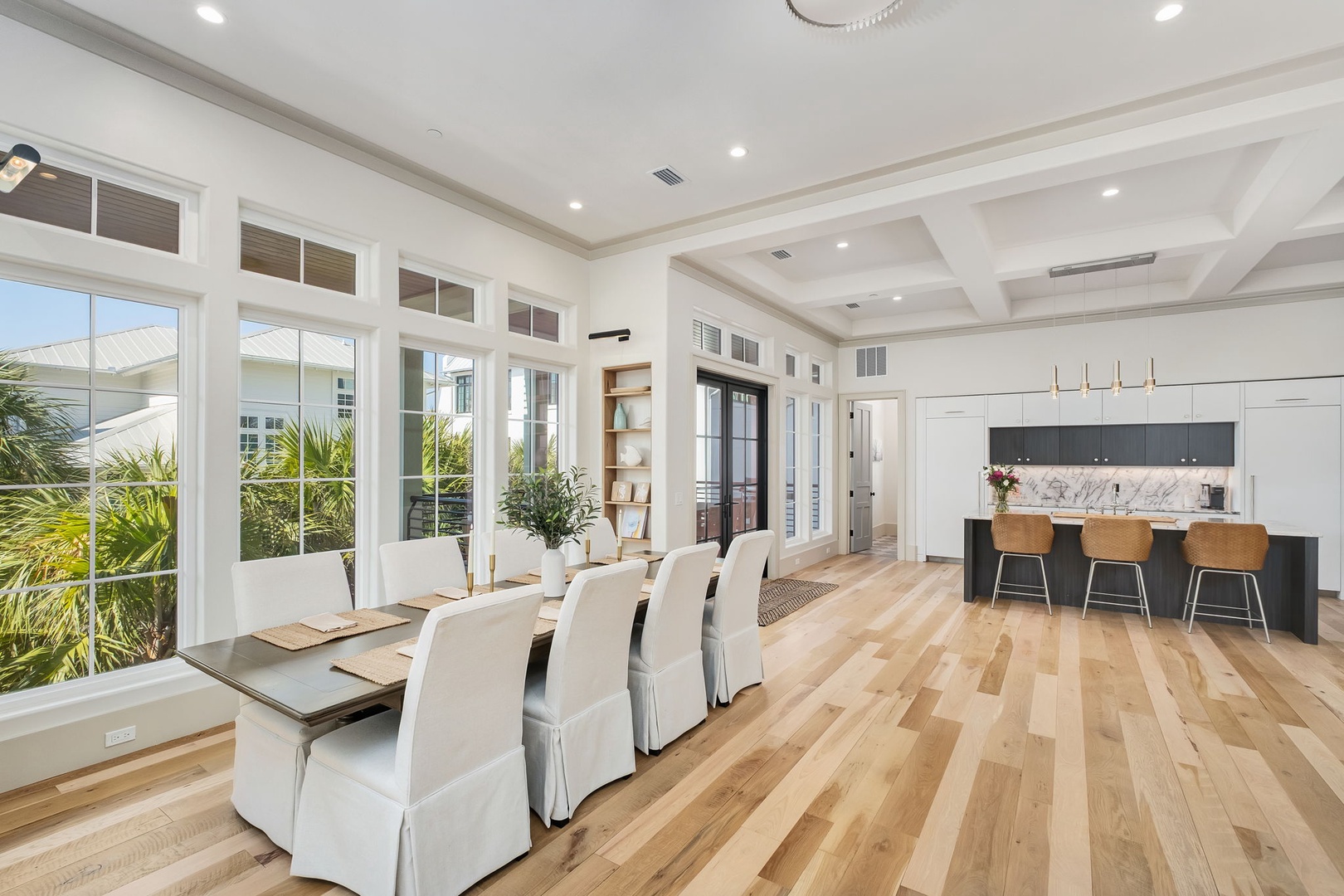 Your open-concept dining and kitchen space blends modern elegance with warm hardwood floors and soaring coffered ceilings.