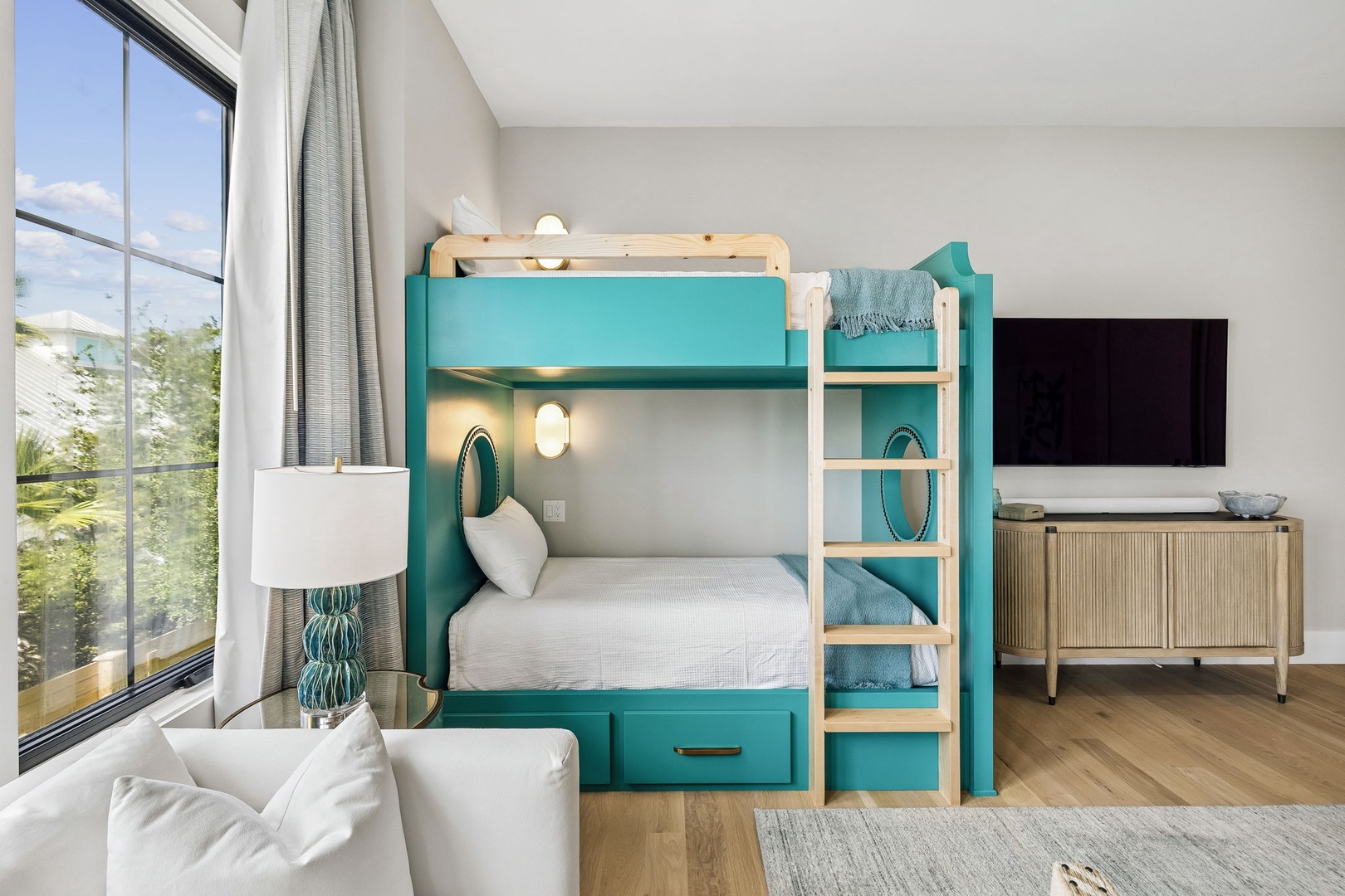 Your kids will love bunking up in this cheerful room, with its vibrant teal bunk beds, cozy linens, and entertainment setup—perfect for family bonding and carefree vacation moments.