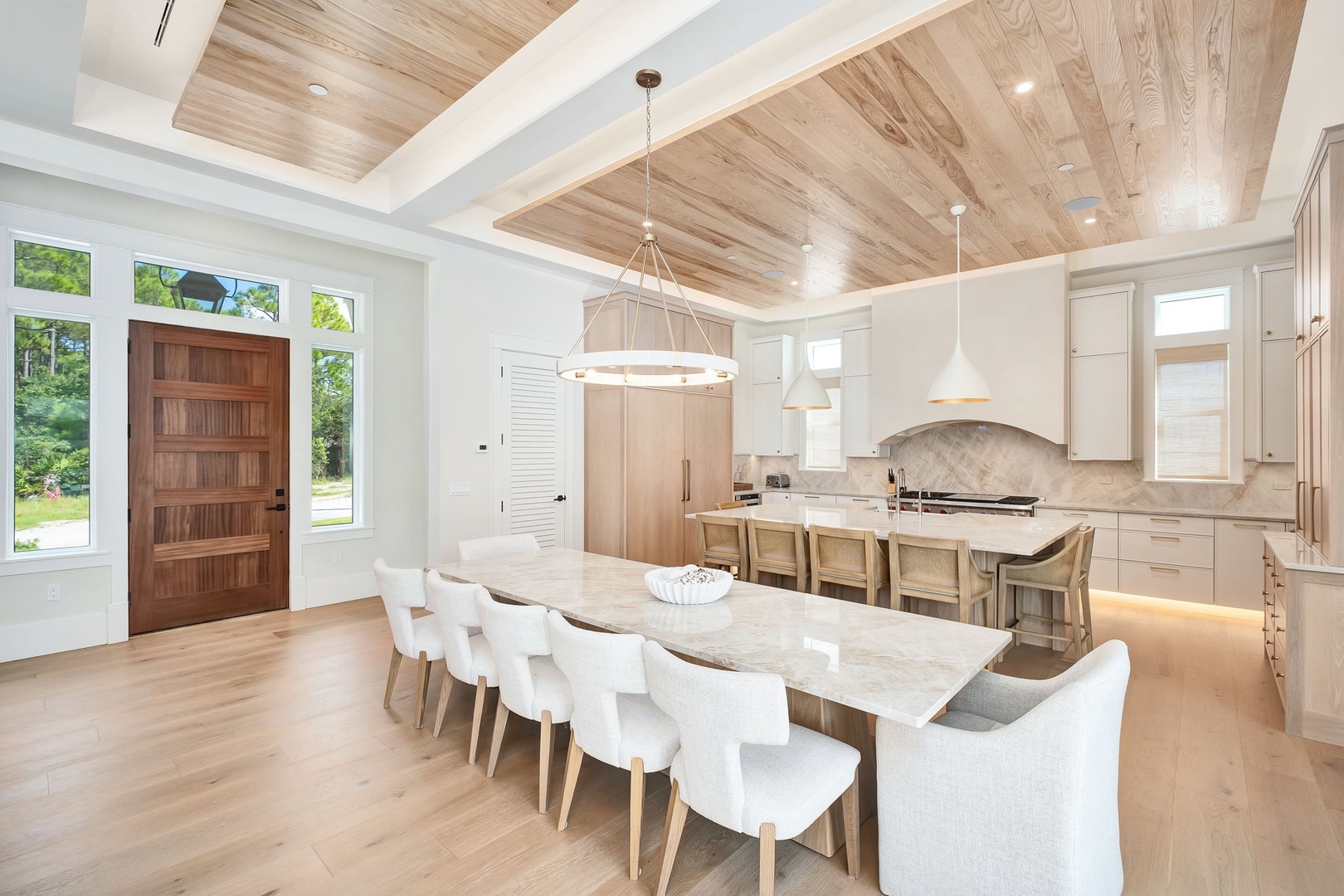Your gourmet kitchen flows seamlessly into an elegant dining area beneath warm wood ceilings, perfect for gathering everyone together over delicious meals and memorable conversations.