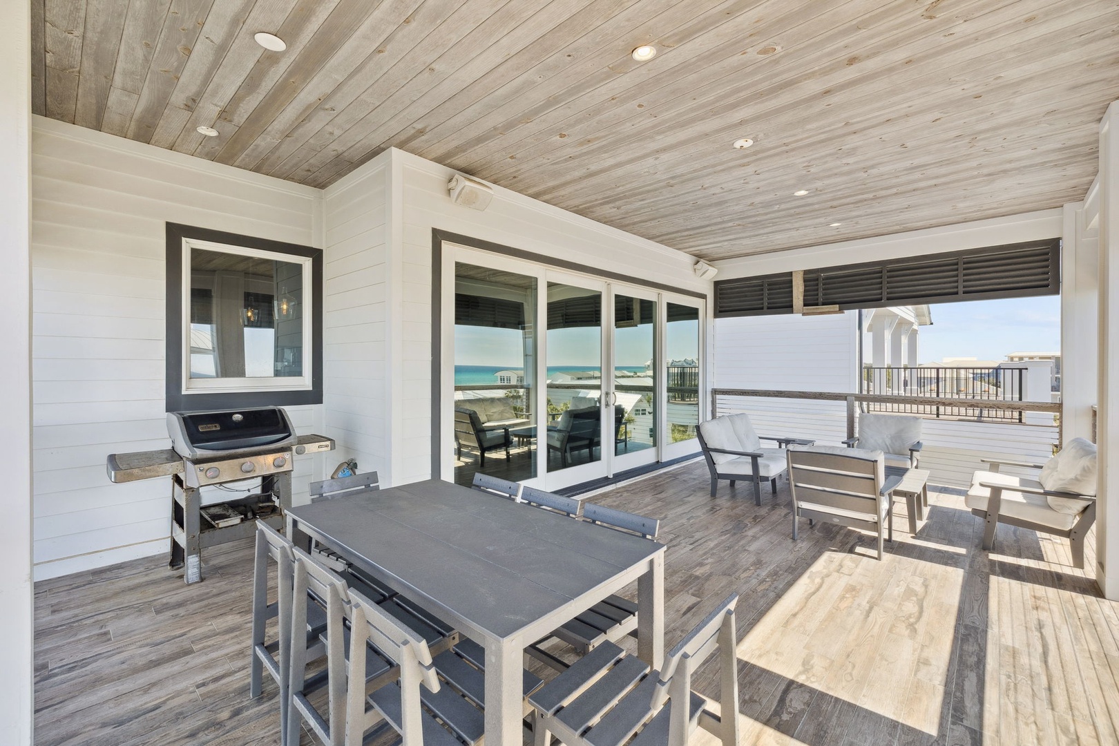 Your covered deck offers perfect beachfront dining with ocean views, outdoor table, grill, and comfortable seating for memorable coastal meals.