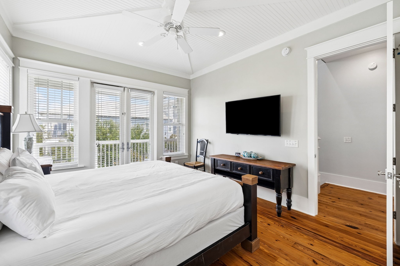 Sink into crisp linens and wake to gentle sunlight streaming through French doors opening to your private deck, where the calming rhythm of the water awaits just beyond.