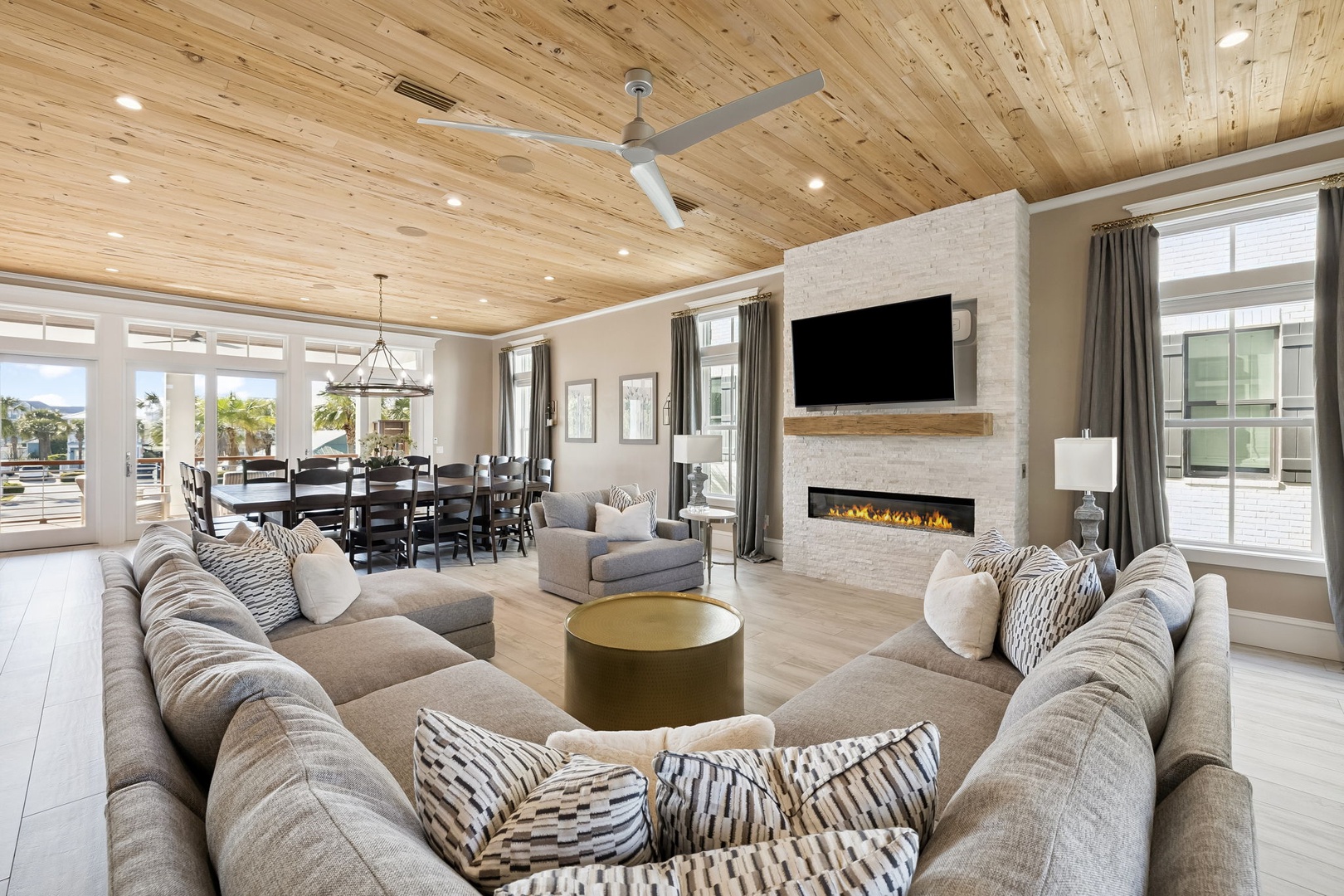 Relax in your spacious living room with soaring wood ceilings, cozy fireplace, and panoramic views through floor-to-ceiling windows.