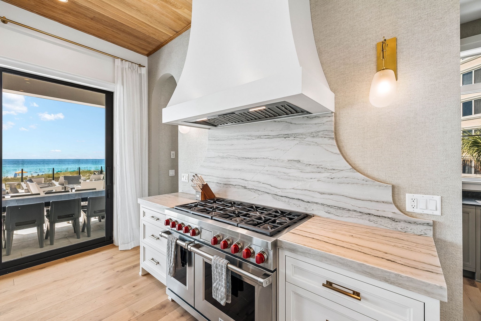 Cook with the ocean as your backdrop in this stunning beach-view kitchen, where a chef's dream stove meets coastal elegance and natural light.