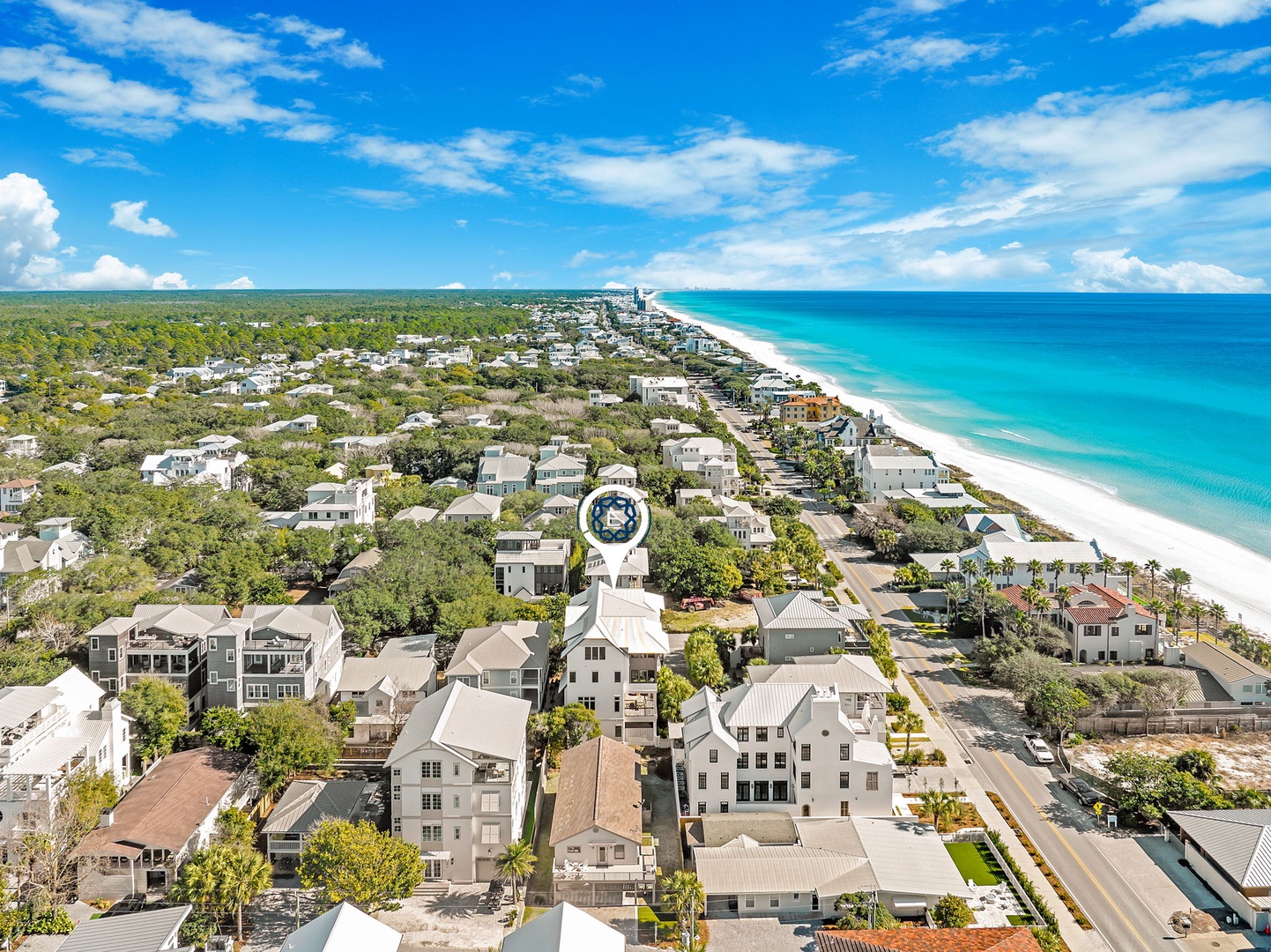 Coastal community with pristine white sand beach and turquoise waters, surrounded by lush vegetation and residential neighborhoods.