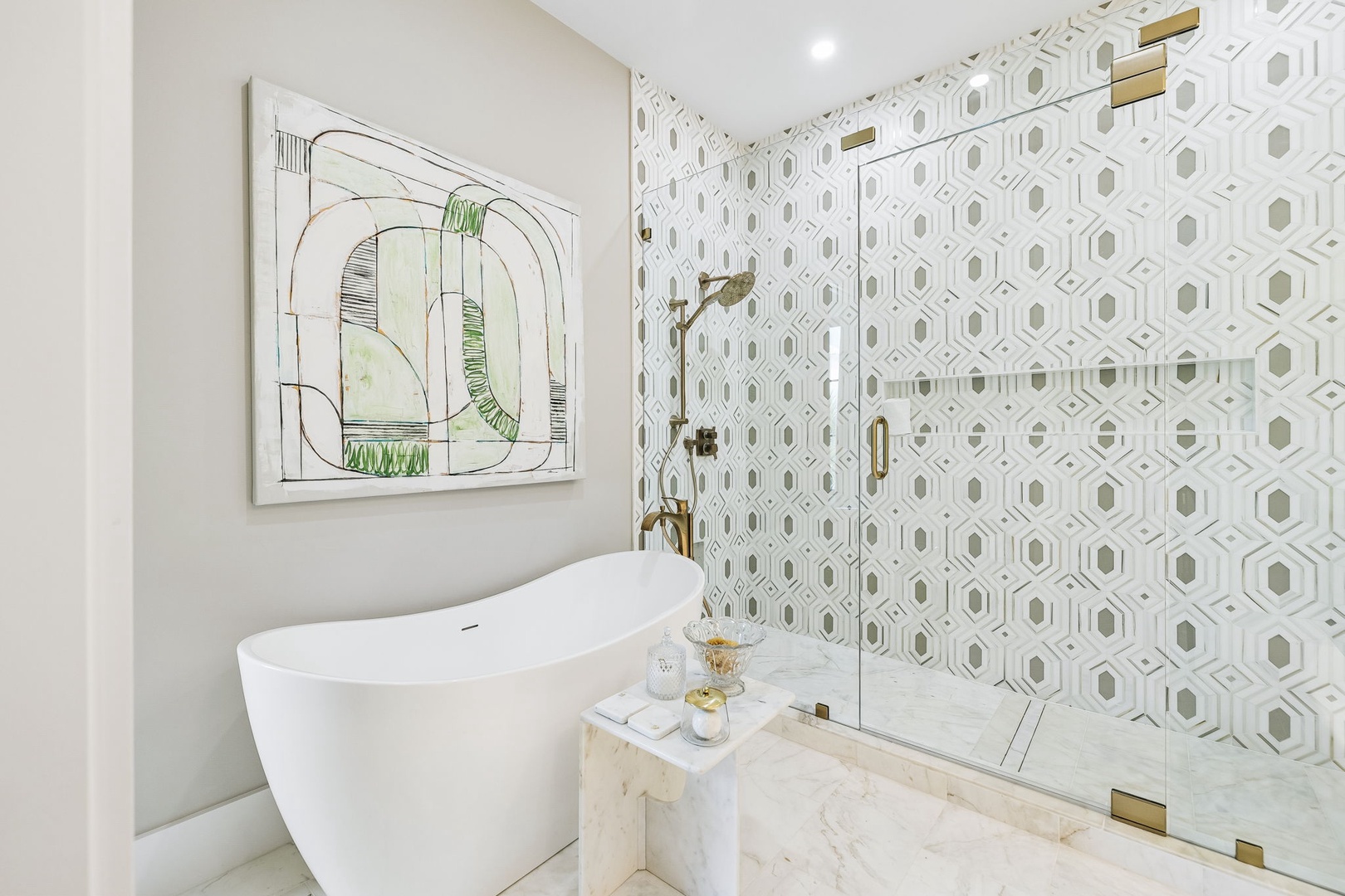 Soak away the day in your elegant freestanding tub, or step into the spacious walk-in shower with chic geometric tile and polished brass fixtures.
