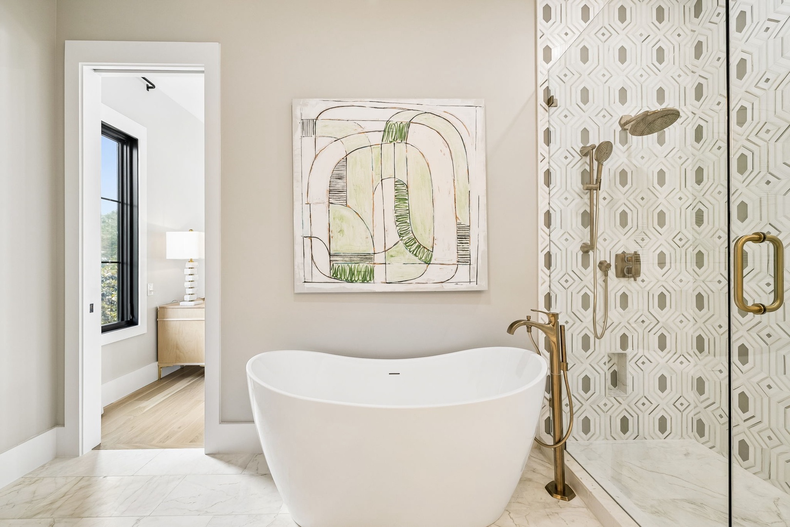 Sink into this sculptural soaking tub where soft tones and artful details create your personal spa retreat, complete with a spacious walk-in shower.