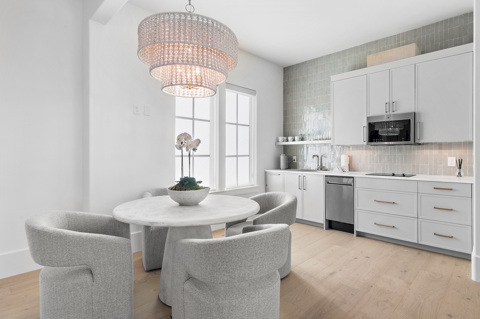 Gather around the elegant marble table beneath a stunning chandelier, with a sleek kitchenette ready for your morning coffee or evening wine. Natural light and chic design invite you to unwind.