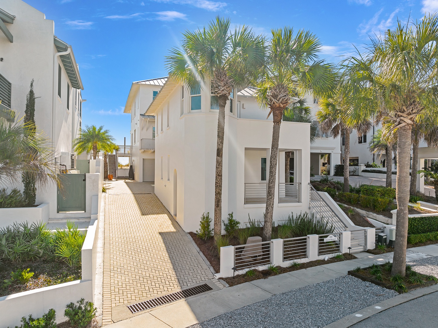 Modern coastal retreat featuring pristine white architecture and swaying palm trees in an exclusive beachside neighborhood.