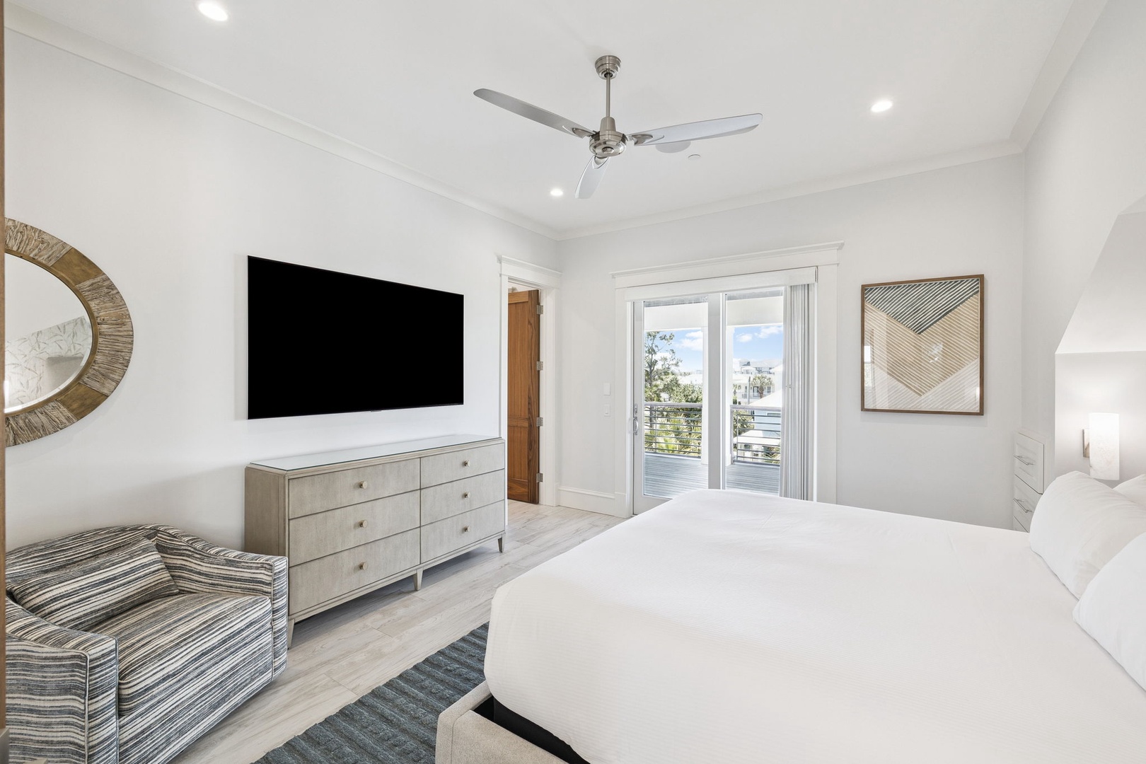 Your modern bedroom features crisp white linens, stylish furnishings, and a large TV for ultimate relaxation after exploring.