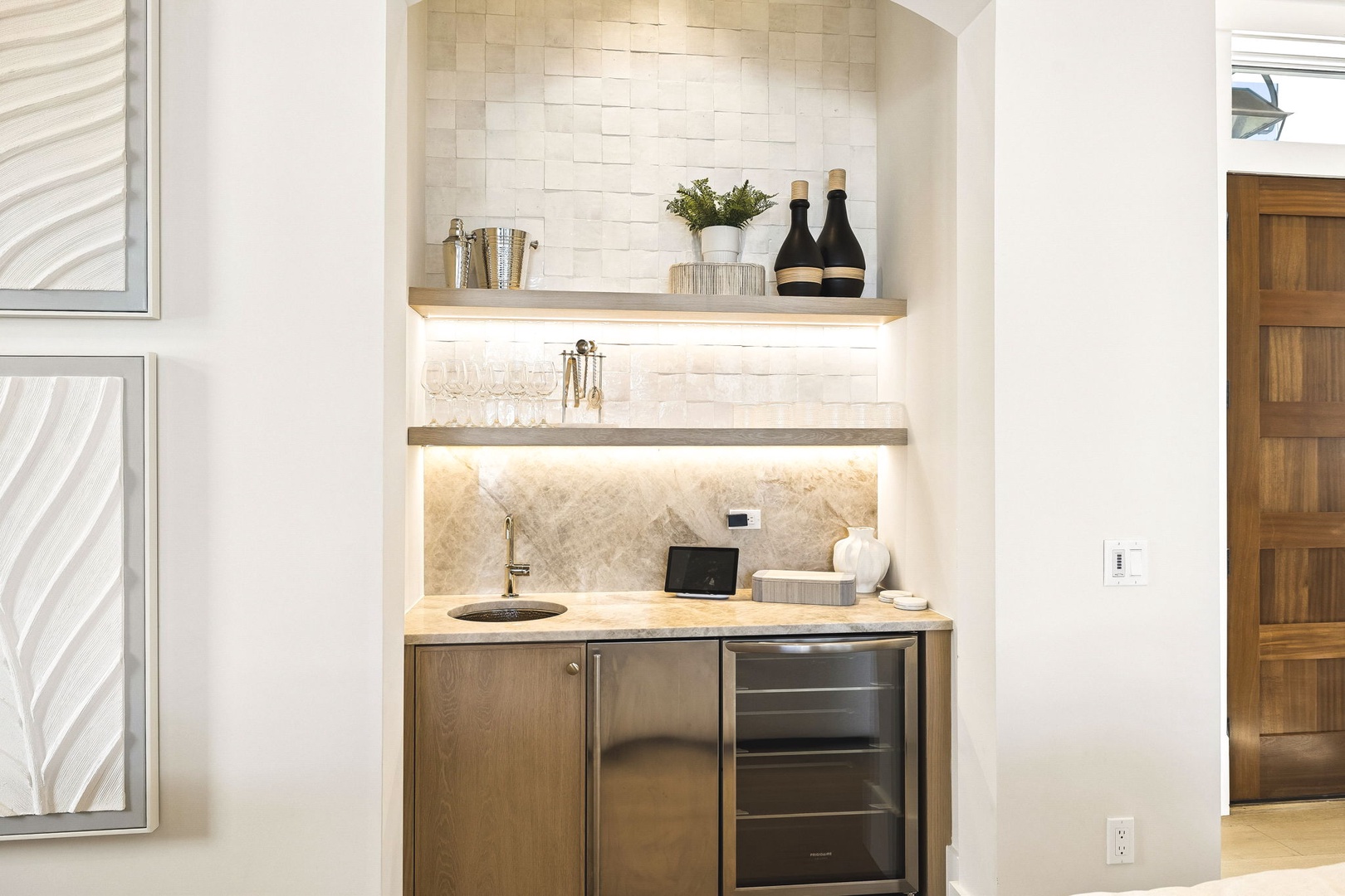 Your stylish wet bar nook features illuminated floating shelves, a wine fridge, and elegant backsplash—perfect for mixing drinks or unwinding after a day of adventure.
