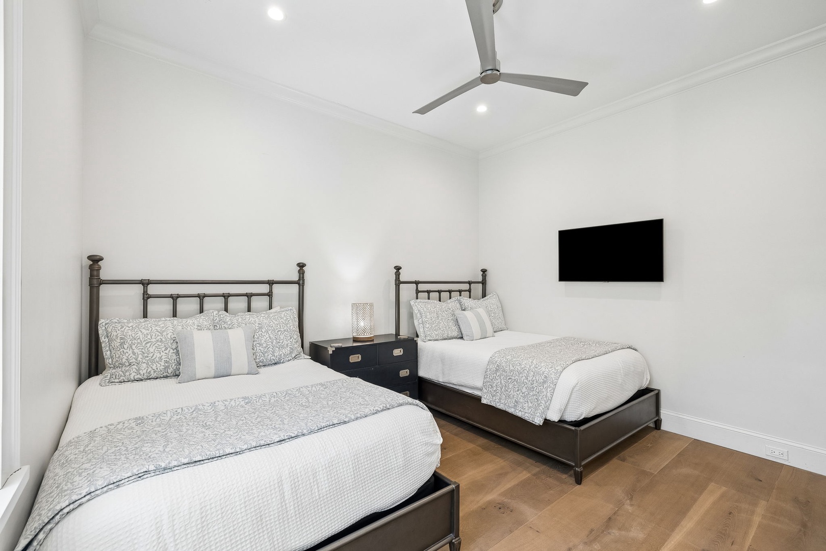 Settle into your bright, airy guest room with twin beds dressed in plush linens, a ceiling fan to keep you cool, and a wall-mounted TV for your downtime.