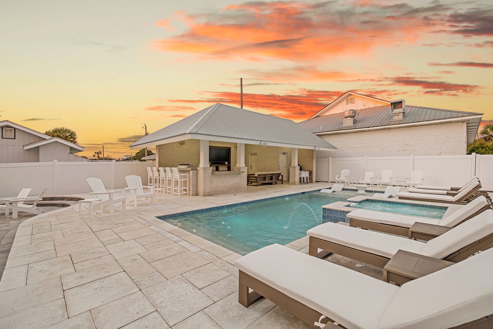 Stunning sunset poolside paradise with outdoor kitchen and lounge chairs awaiting your perfect evening.