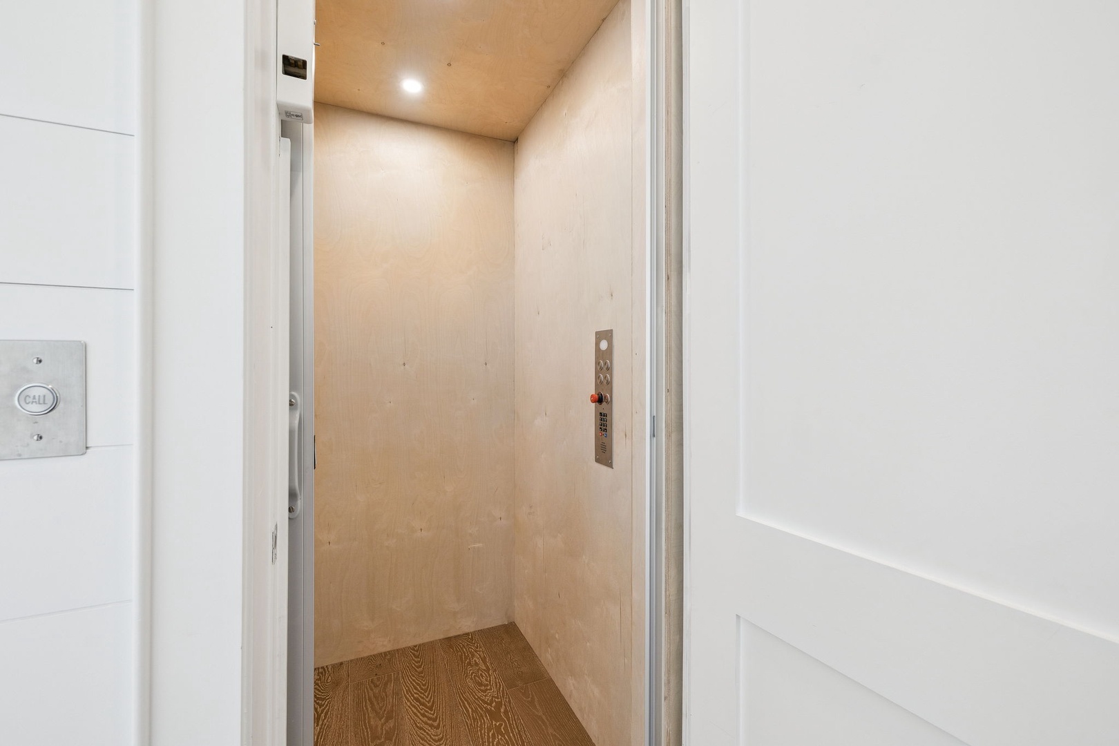 Step into your private elevator for effortless access to your floor, complete with modern controls and warm wood finishes.