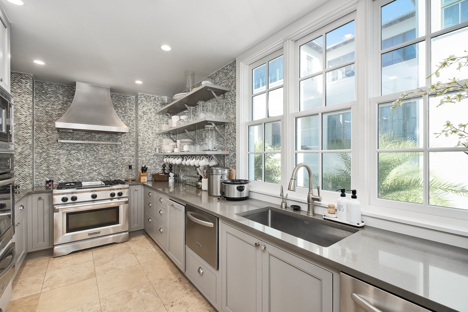 Cook gourmet meals in your fully equipped kitchen with professional appliances, gleaming countertops, and bright windows overlooking lush tropical gardens.