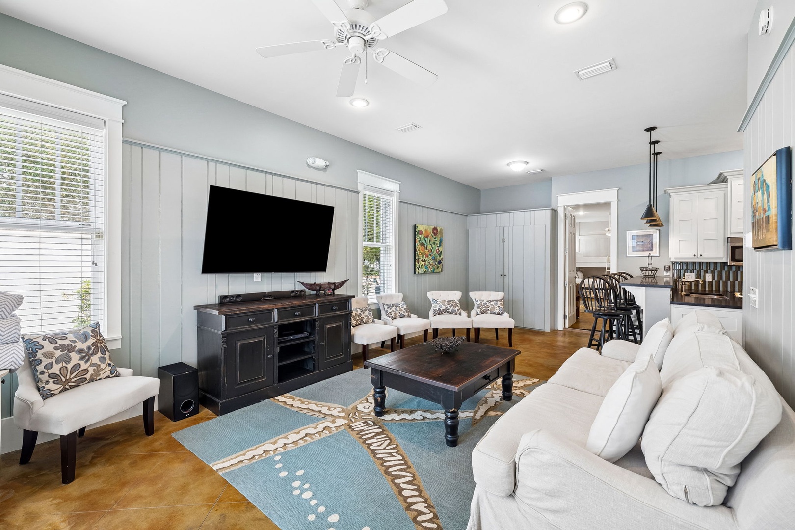 Sink into plush seating and unwind in your light-filled living area, where coastal charm meets comfort with elegant furnishings and a welcoming open layout.