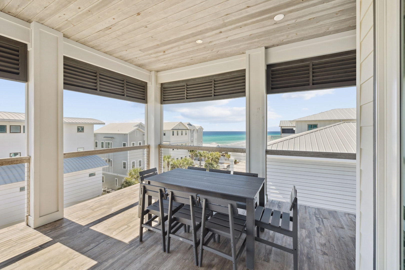 Savor your morning coffee at this covered dining nook, where coastal breezes and turquoise sea views create the perfect breakfast spot.