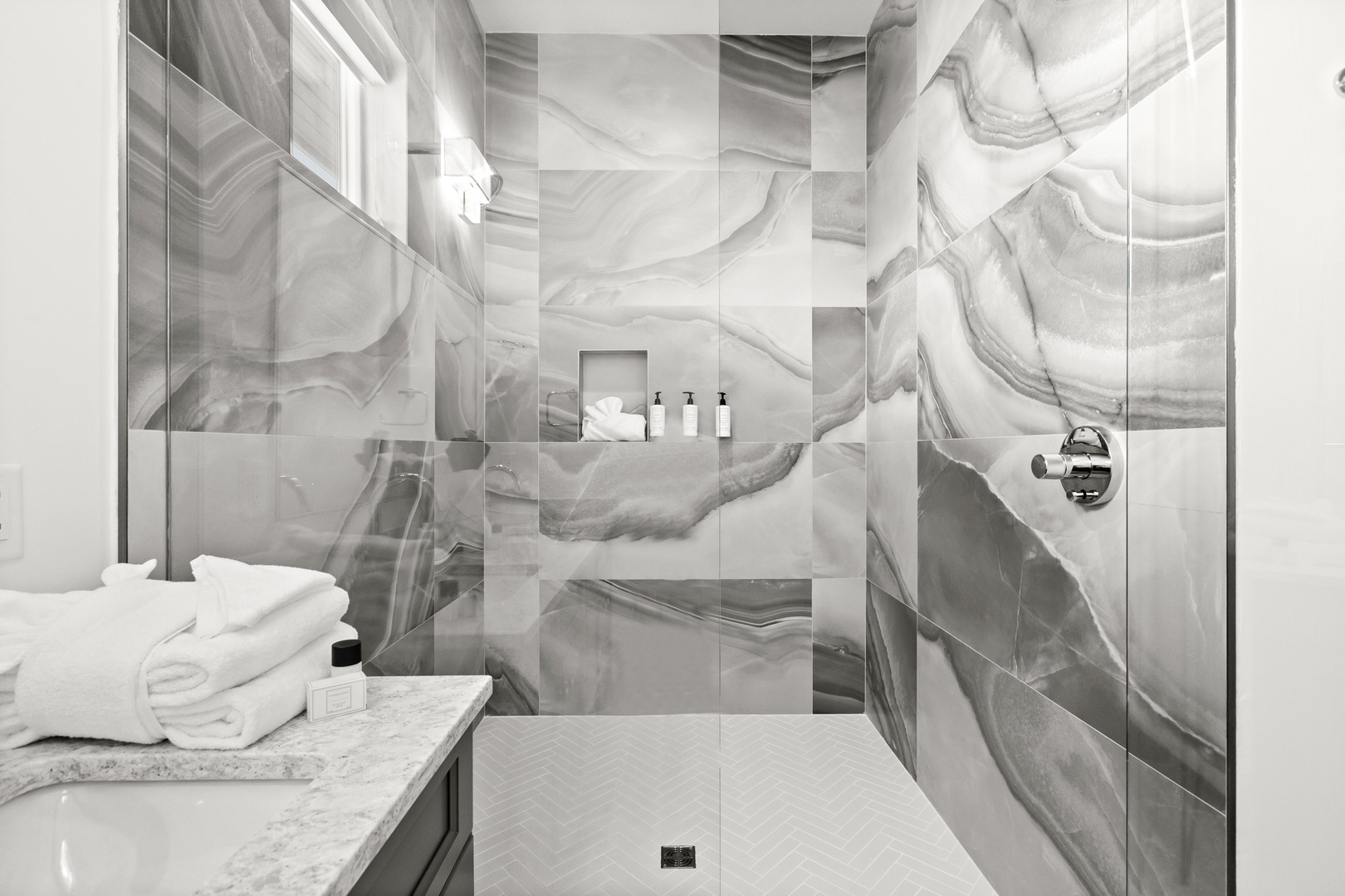 Step into your luxurious spa-like bathroom where stunning marble walls and a sleek walk-in shower invite you to unwind in pure elegance.