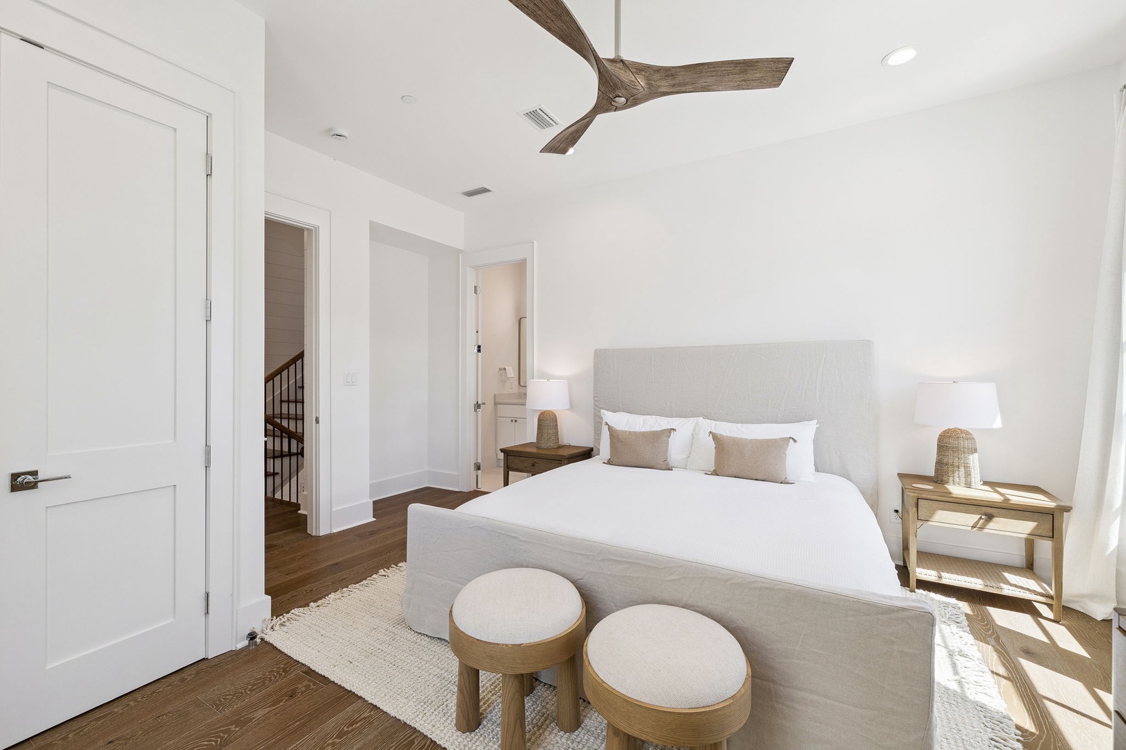 Sink into crisp white linens and natural textures in your serene bedroom retreat, where coastal charm meets modern comfort.