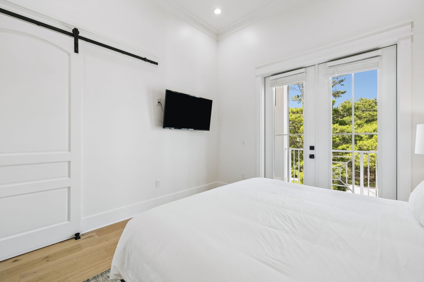 Wake up to lush green views framing your private balcony—this bright, serene bedroom invites you to relax in crisp linens and step outside for morning coffee in the fresh air.