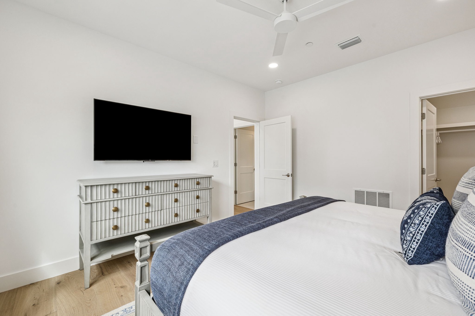 Relax in your serene bedroom featuring a plush bed, stylish dresser, and entertainment. The ceiling fan keeps you comfortable year-round.