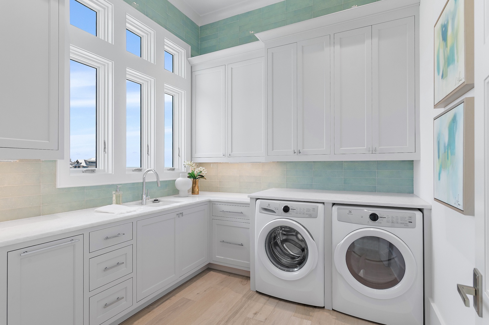 Your dedicated laundry room combines function and style with ocean views through tall windows, soothing coastal-inspired tiling, and a bright, organized workspace to make chores feel effortless.