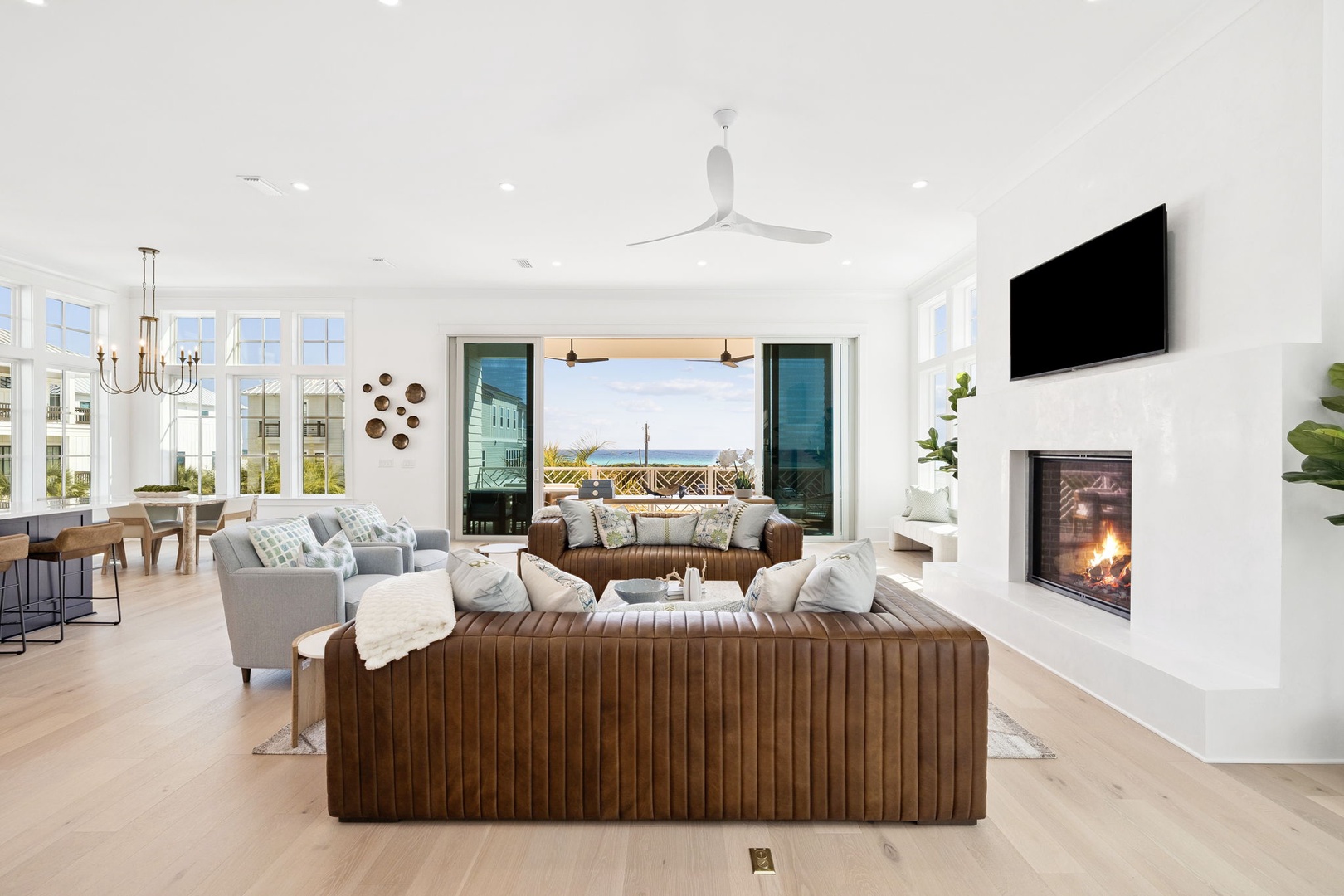 Unwind in your luxurious open-concept living space with a cozy fireplace and stunning water views through floor-to-ceiling windows.