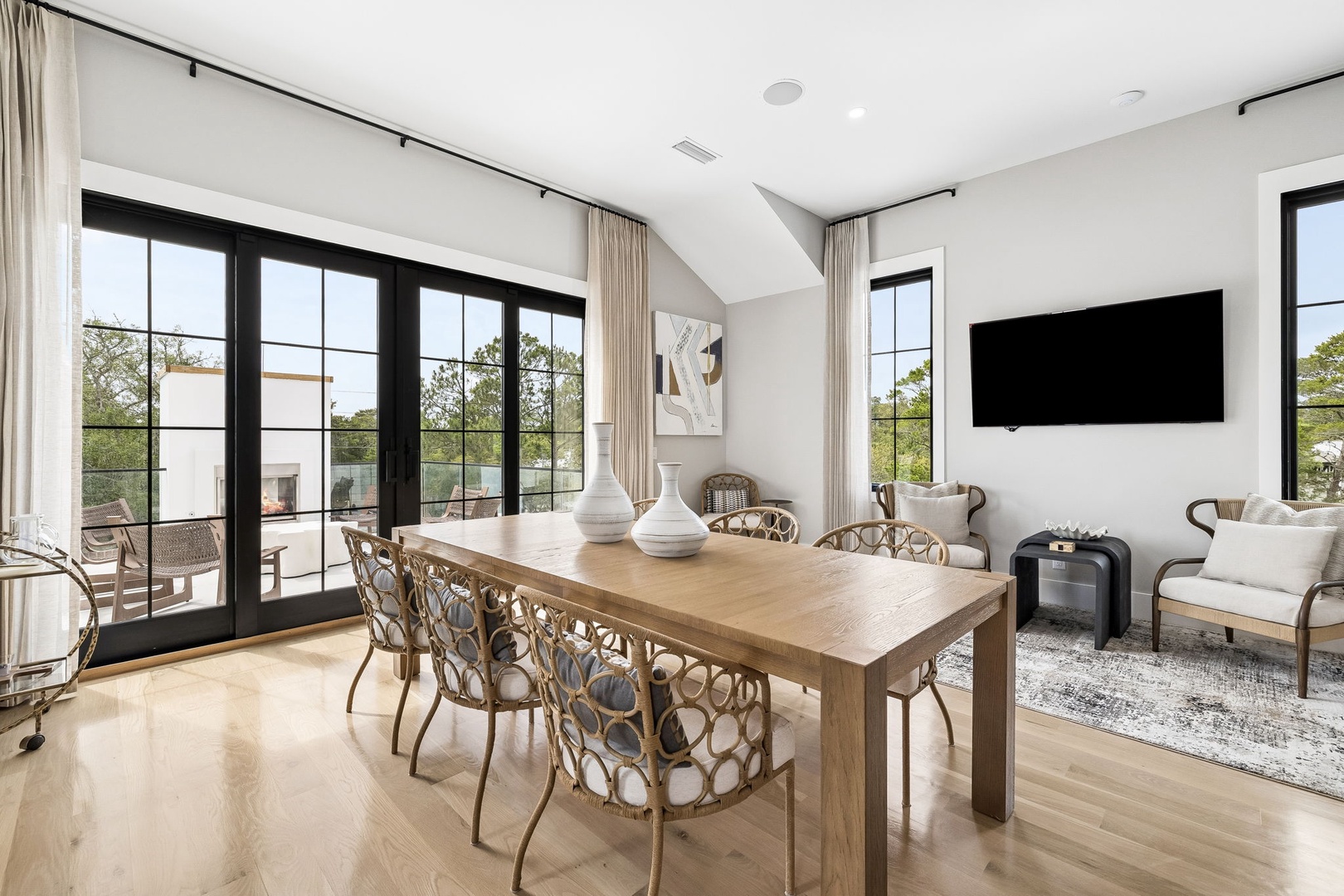 Gather around the sleek dining table or relax in the lounge area, where natural light pours through floor-to-ceiling windows, framing your private balcony and peaceful treetop views.