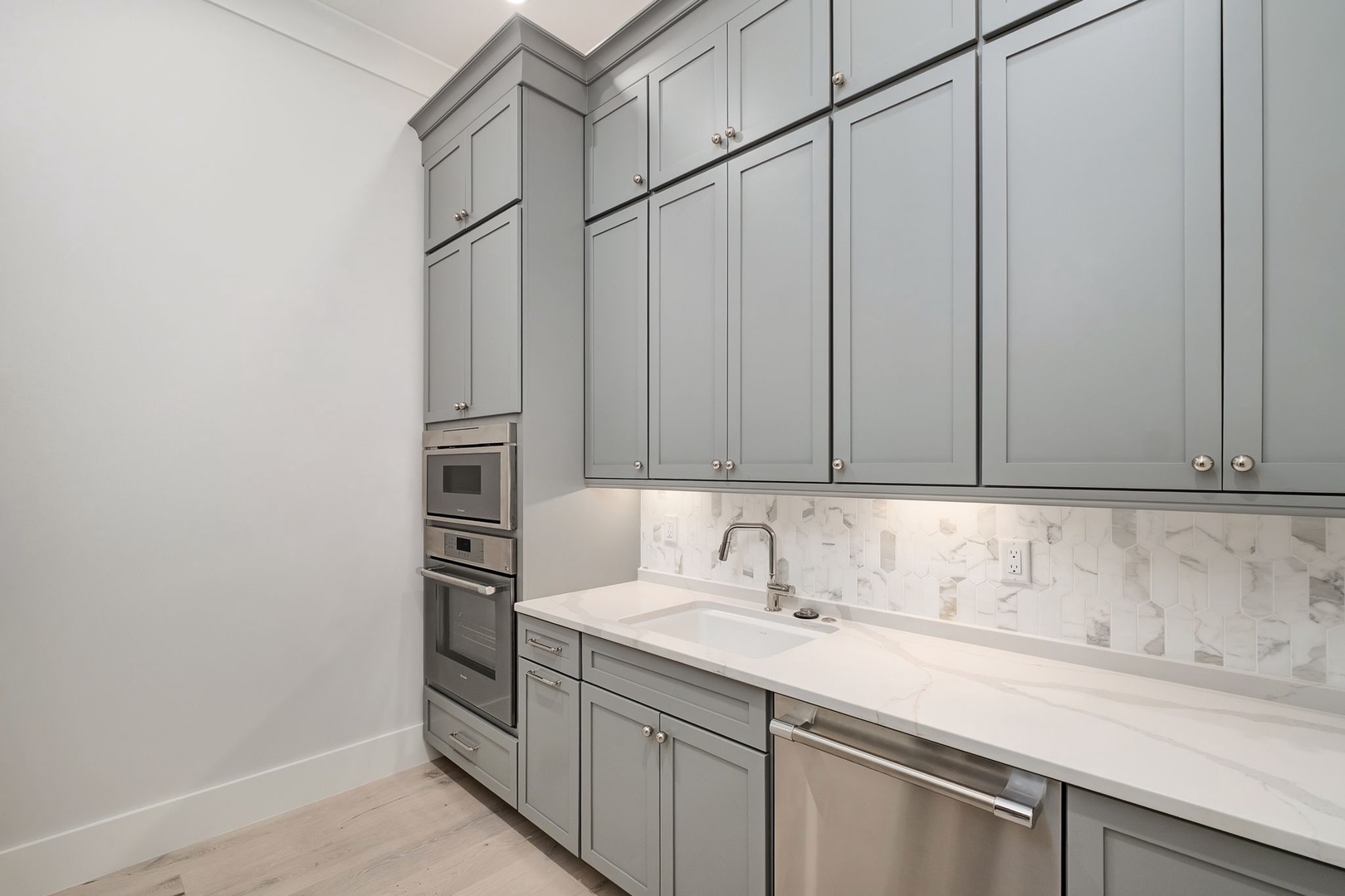 Your gourmet kitchen features elegant gray cabinetry, marble countertops, and premium stainless steel appliances for memorable cooking experiences.