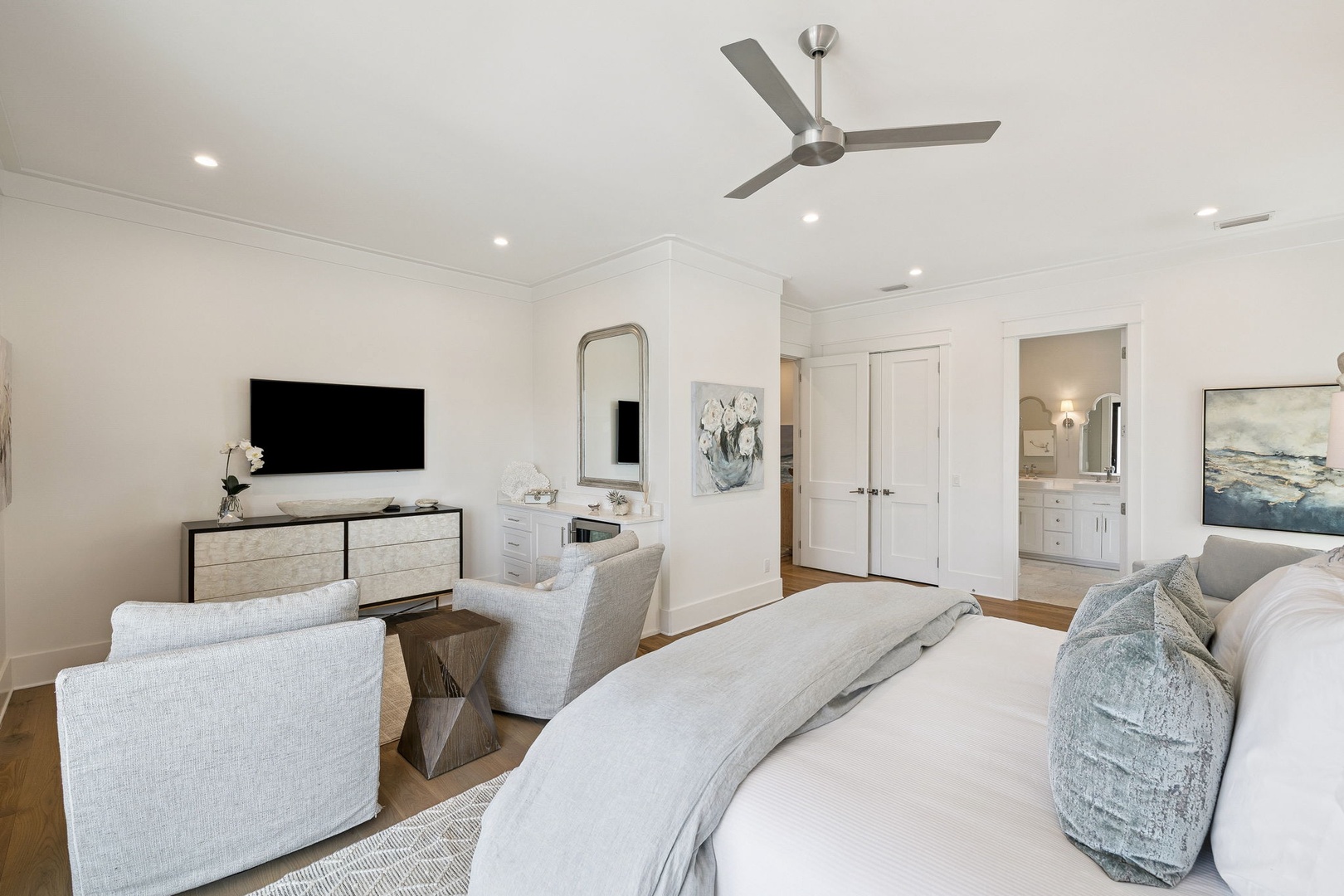 Your serene bedroom sanctuary features luxury linens, modern seating, and coastal artwork creating the perfect retreat for restful nights.