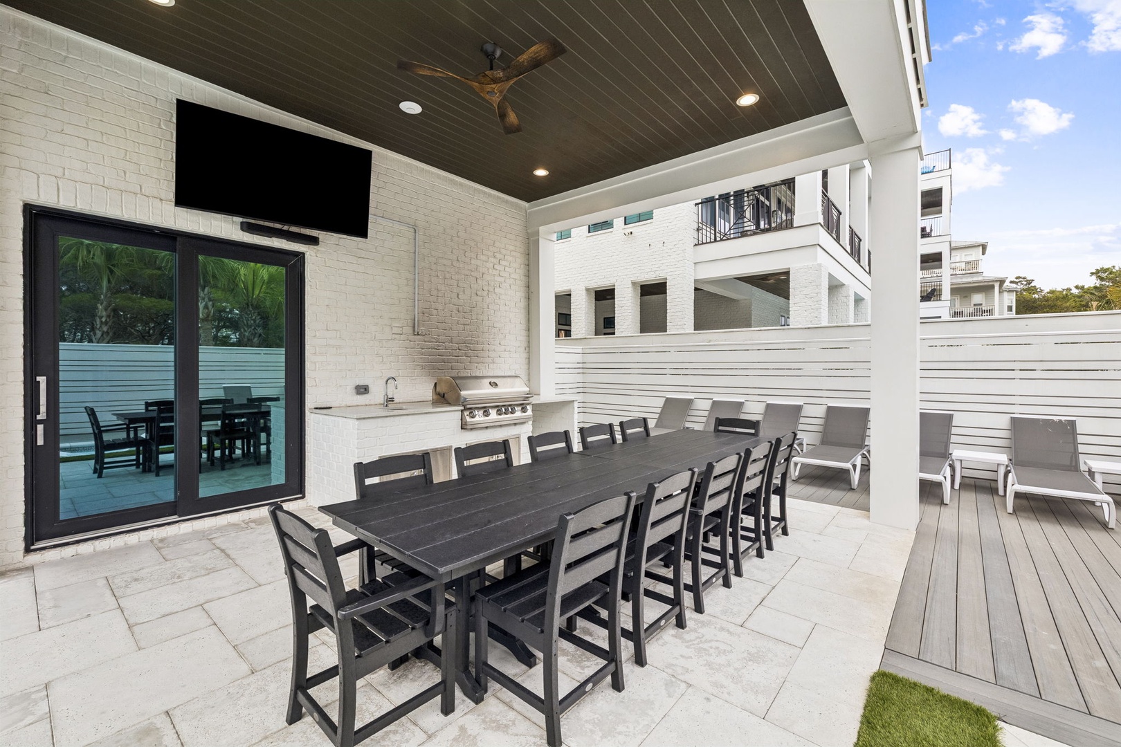 Your covered outdoor dining space features a large table for group meals and a built-in BBQ station for perfect evenings.