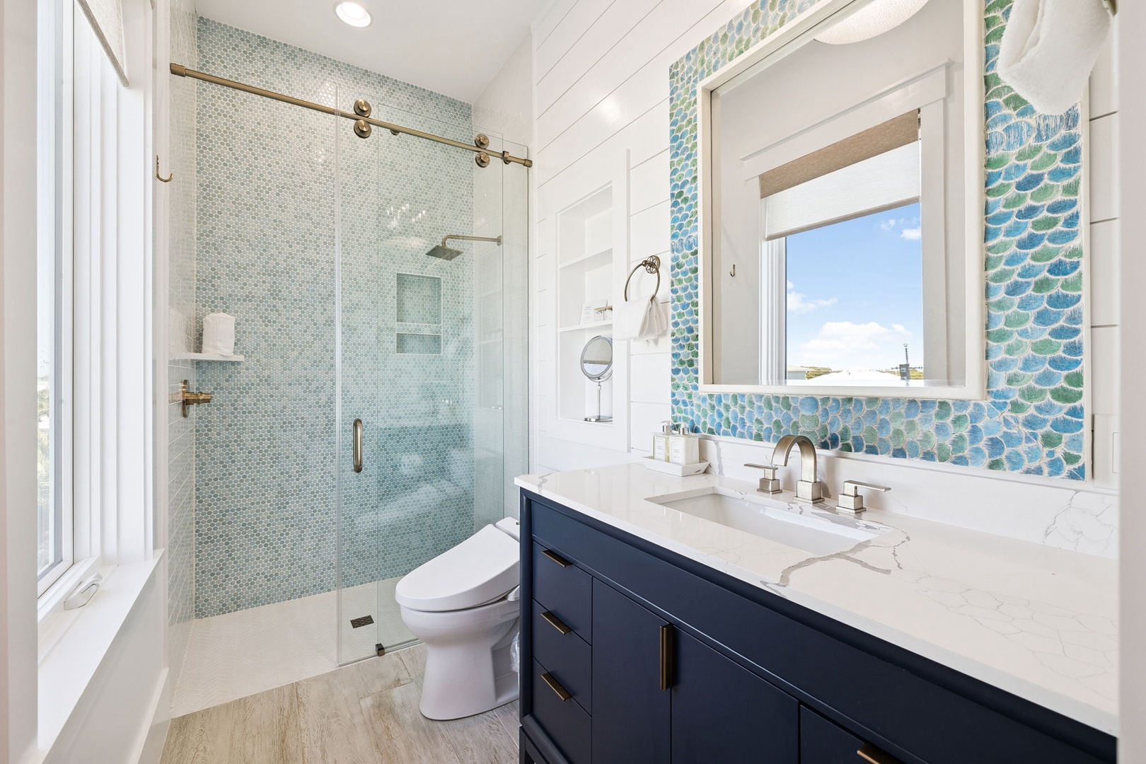 Refresh in your spa-like bathroom with stunning ocean-inspired tiles, spacious glass shower, and bright natural light.