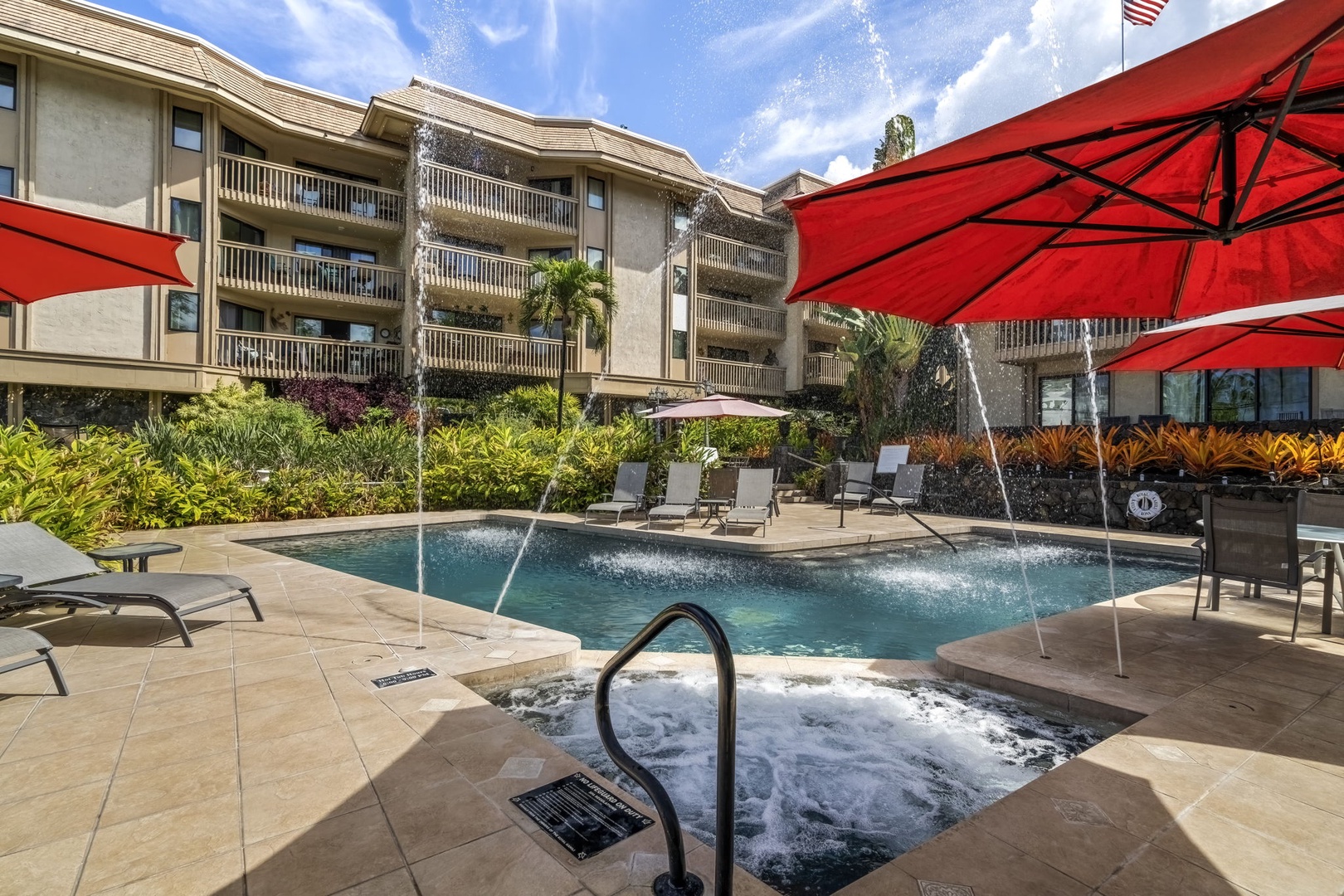 Kailua Kona Vacation Rentals, Royal Kahili 401A - Hot tub area next to the pool with seating for four, shaded by red umbrellas.