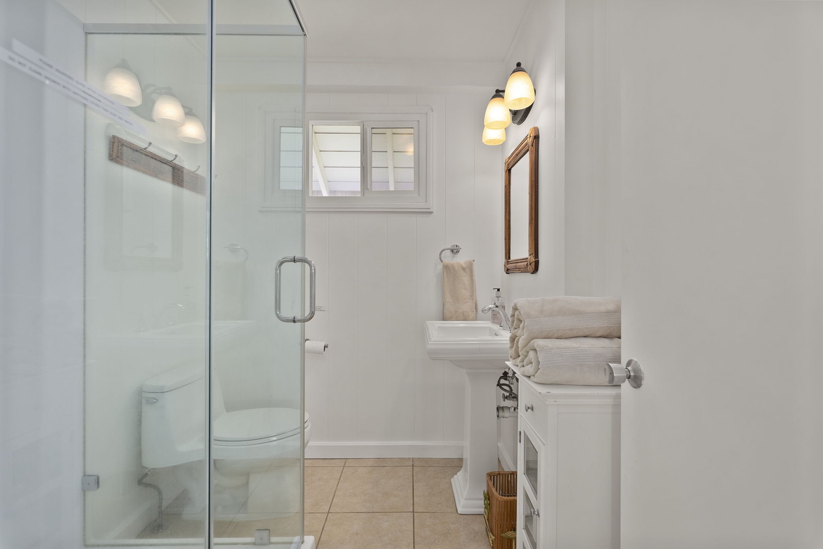 Waianae Vacation Rentals, Ma'ili Blue Estate - Step into your bright, modern bathroom featuring a spacious glass shower and pristine white vanity with fresh towels awaiting your arrival.