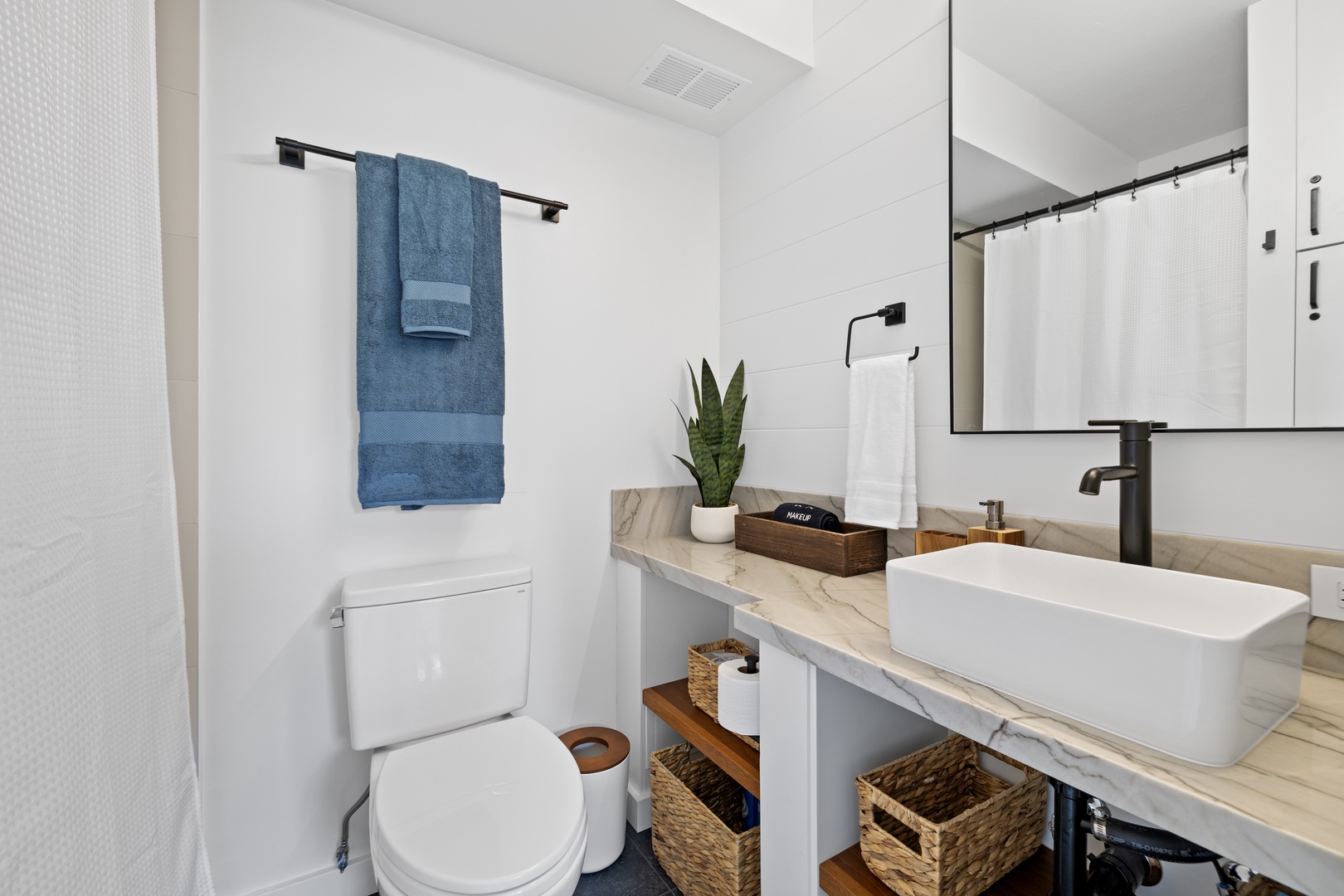 Honolulu Vacation Rentals, Hale Pono Waikiki - Freshen up in this stylish bathroom featuring a sleek vanity and thoughtful touches of decor.