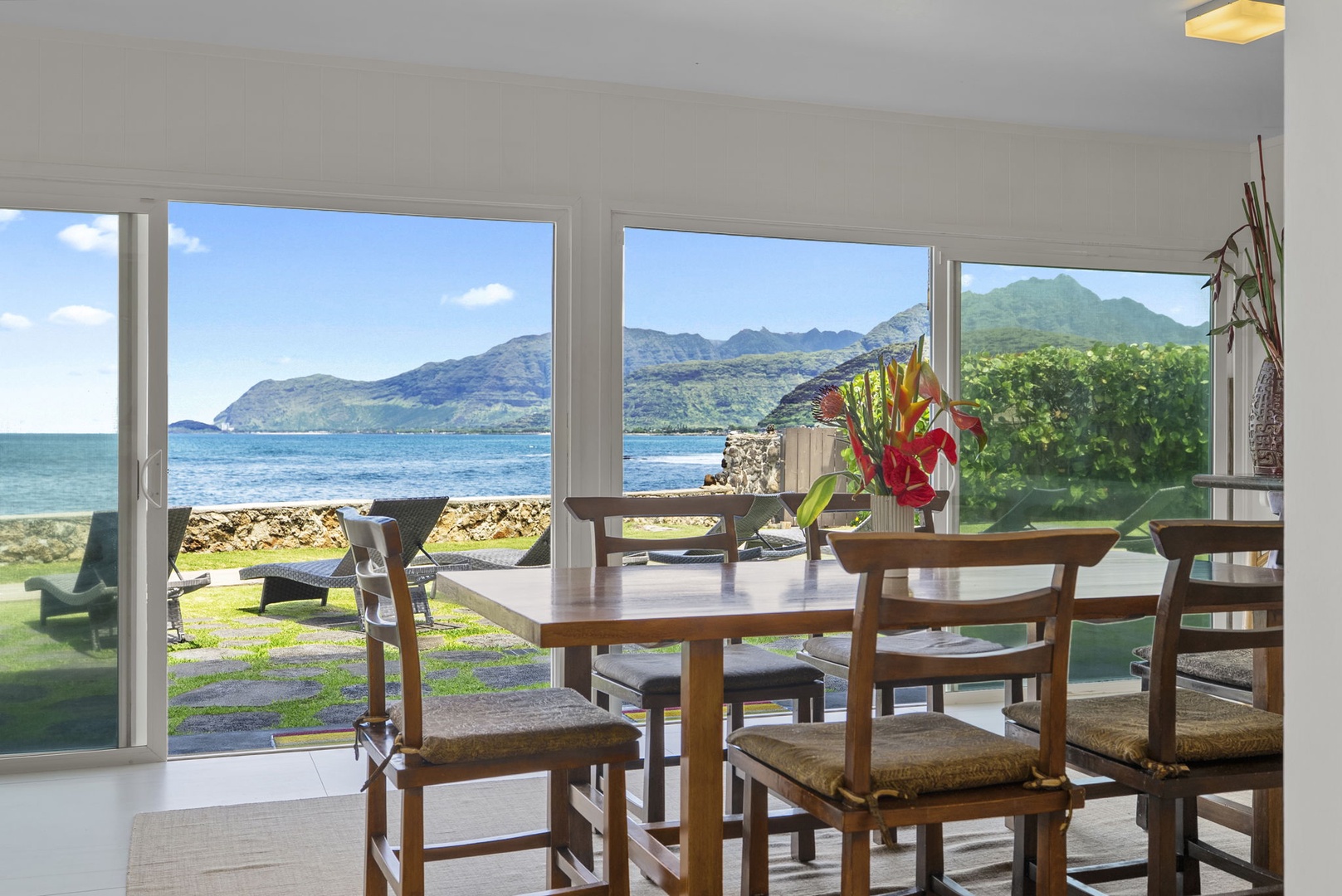 Waianae Vacation Rentals, Ma'ili Blue - Enjoy your morning coffee at this bright dining table while soaking in breathtaking ocean and mountain views through floor-to-ceiling windows.
