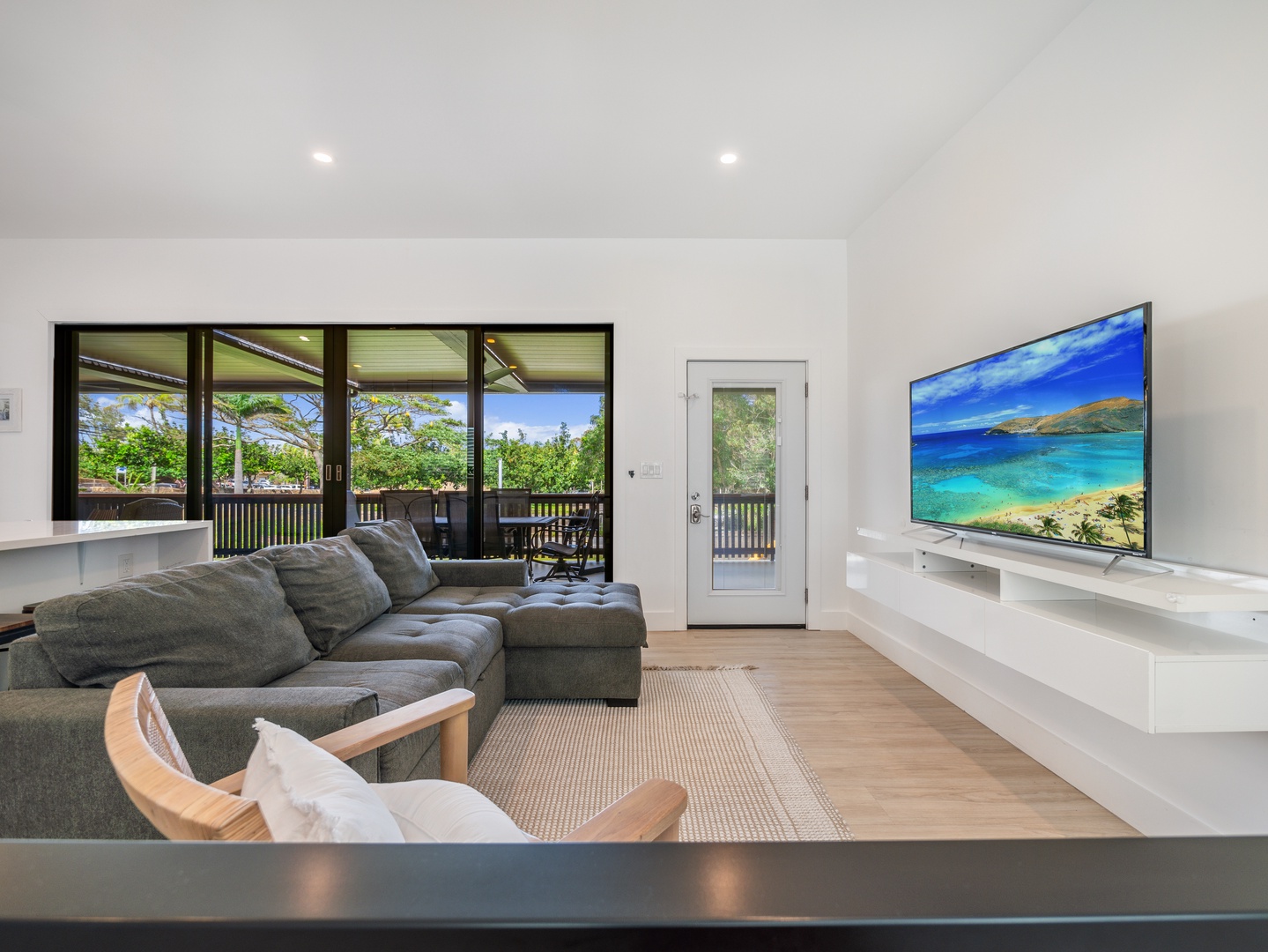 Haleiwa Vacation Rentals, Sunset Beach Island Retreat - Relax in the modern living area, complete with a large sectional couch and a flat-screen TV, offering the perfect space to unwind after a day of adventure.