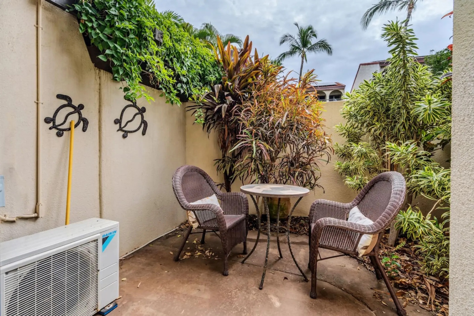 Kihei Vacation Rentals, Maui Kamaole E103 - Two wicker chairs and a small table make this corner the spot for an afternoon book.