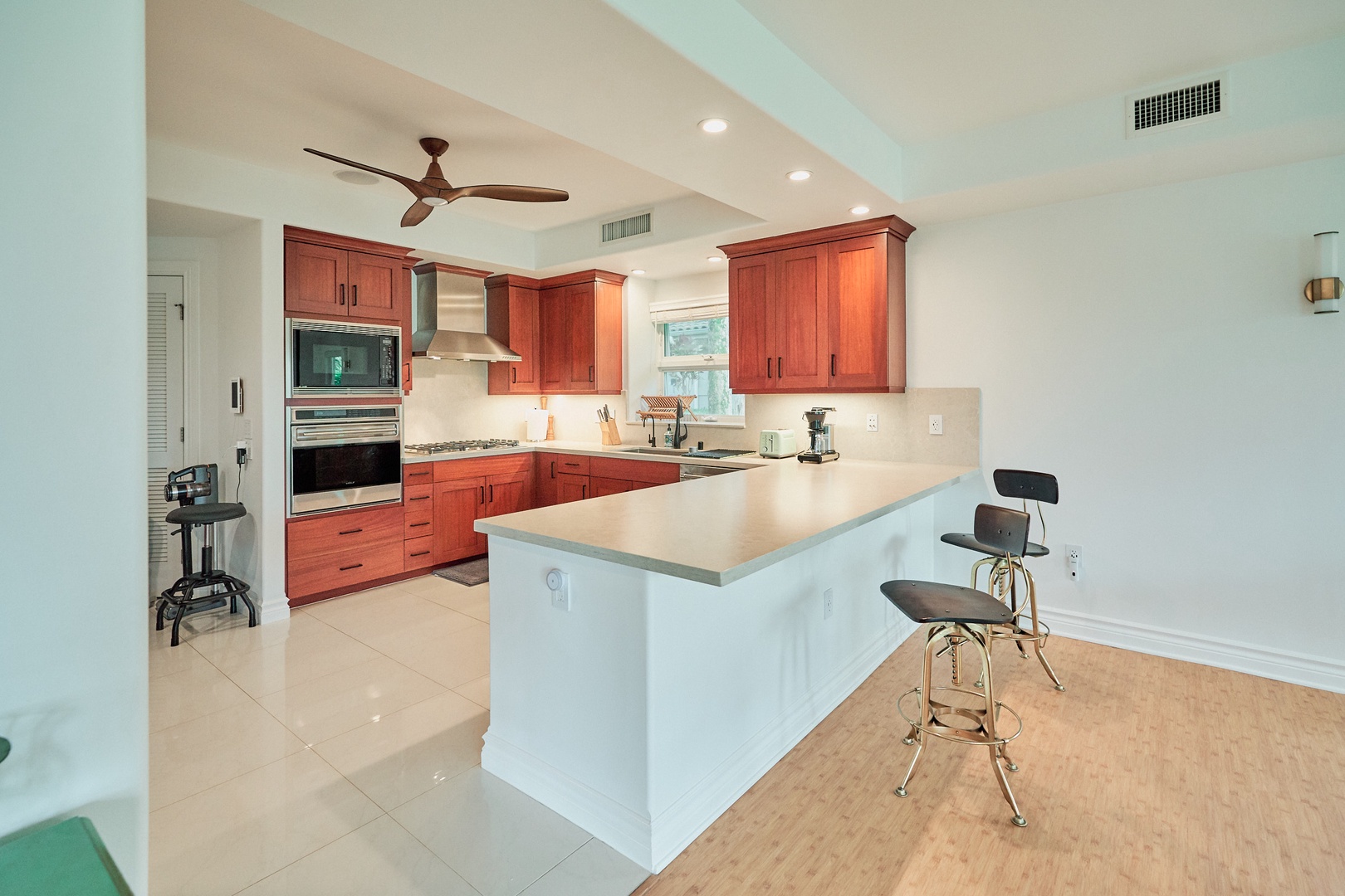 Princeville Vacation Rentals, Hale Kai - Your spacious kitchen features warm wood cabinets, granite counters, and a breakfast bar where you'll love starting your mornings with coffee.