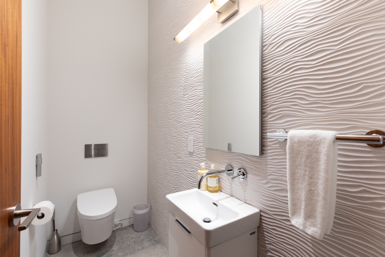 Kamuela Vacation Rentals, Puako’s Ocean Edge Modern Estate - Stylishly appointed with high-end wall treatment and fixtures, this powder room is ideally situated by the Media Room and the kitchen.
