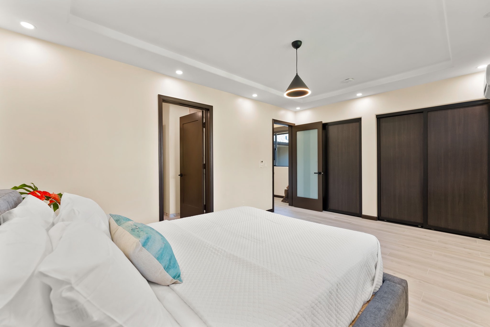 Honolulu Vacation Rentals, Kahala Zen - Spacious bedroom with a king-size bed and modern closet doors.