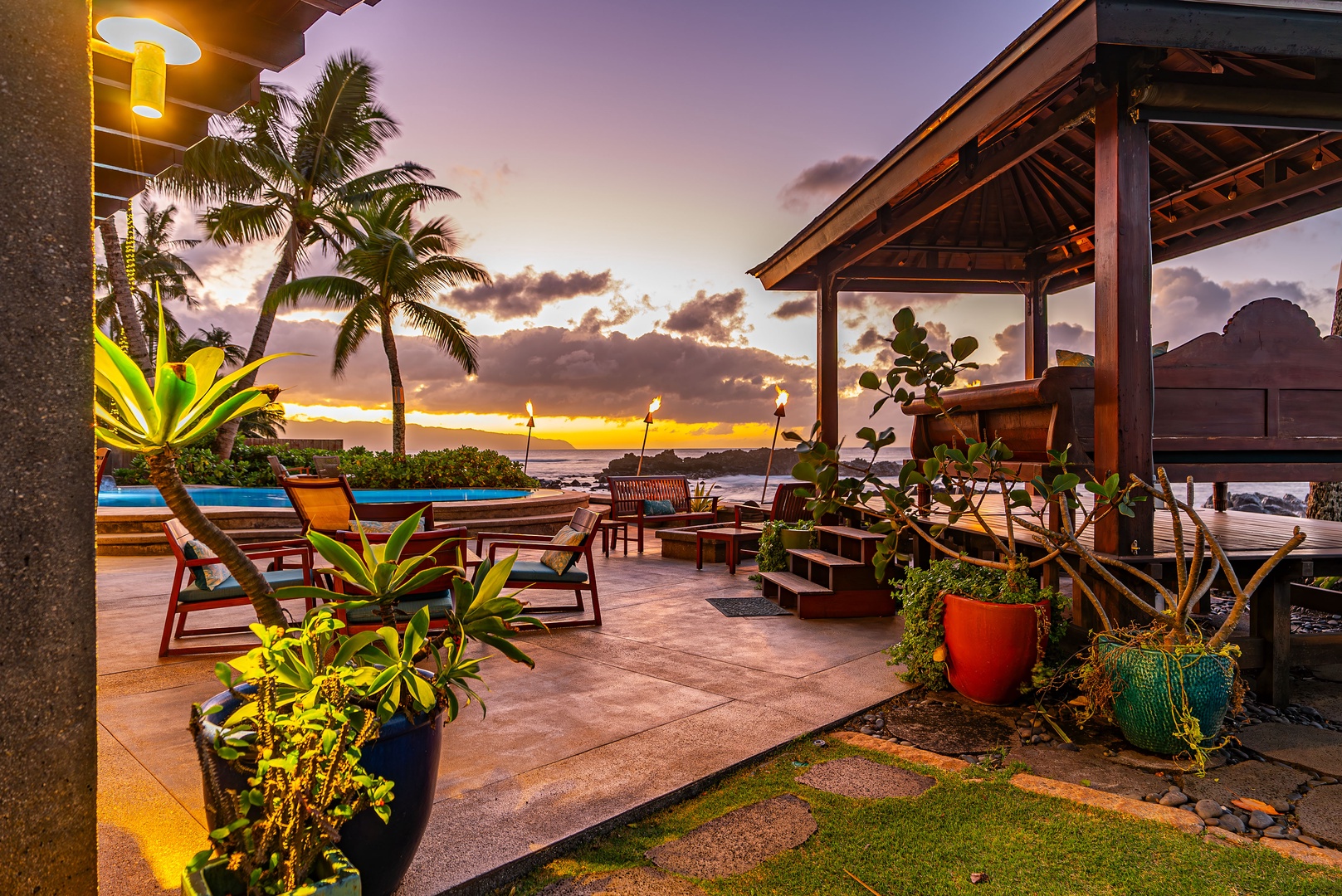 Haleiwa Vacation Rentals, Samurai House - Poolside dining and lounging area illuminated by colorful garden lights.