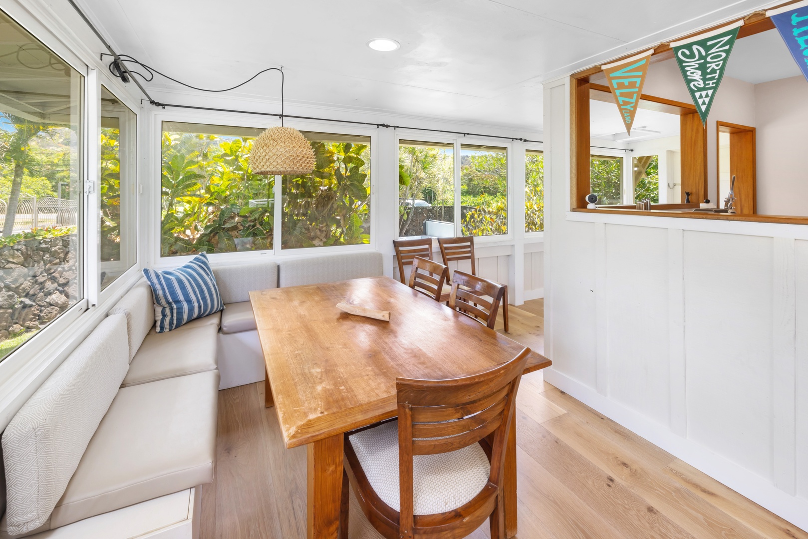 Kahuku Vacation Rentals, Hale Pellicano - The dining area features a cozy built-in bench and wooden table.