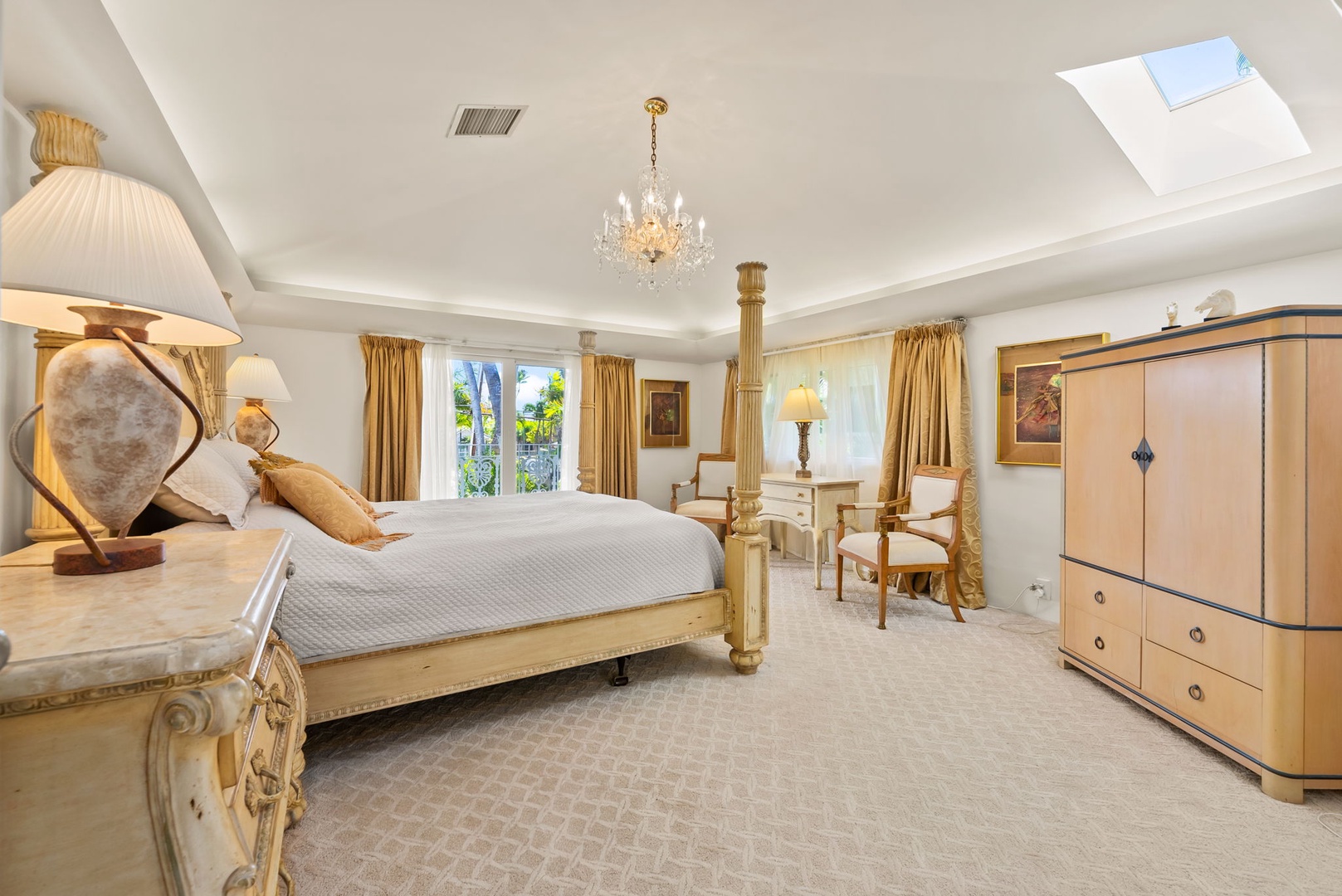 Honolulu Vacation Rentals, Kahala Oasis - Grand primary suite with a four-poster bed, chandeliers, and warm, inviting decor for a luxurious experience.