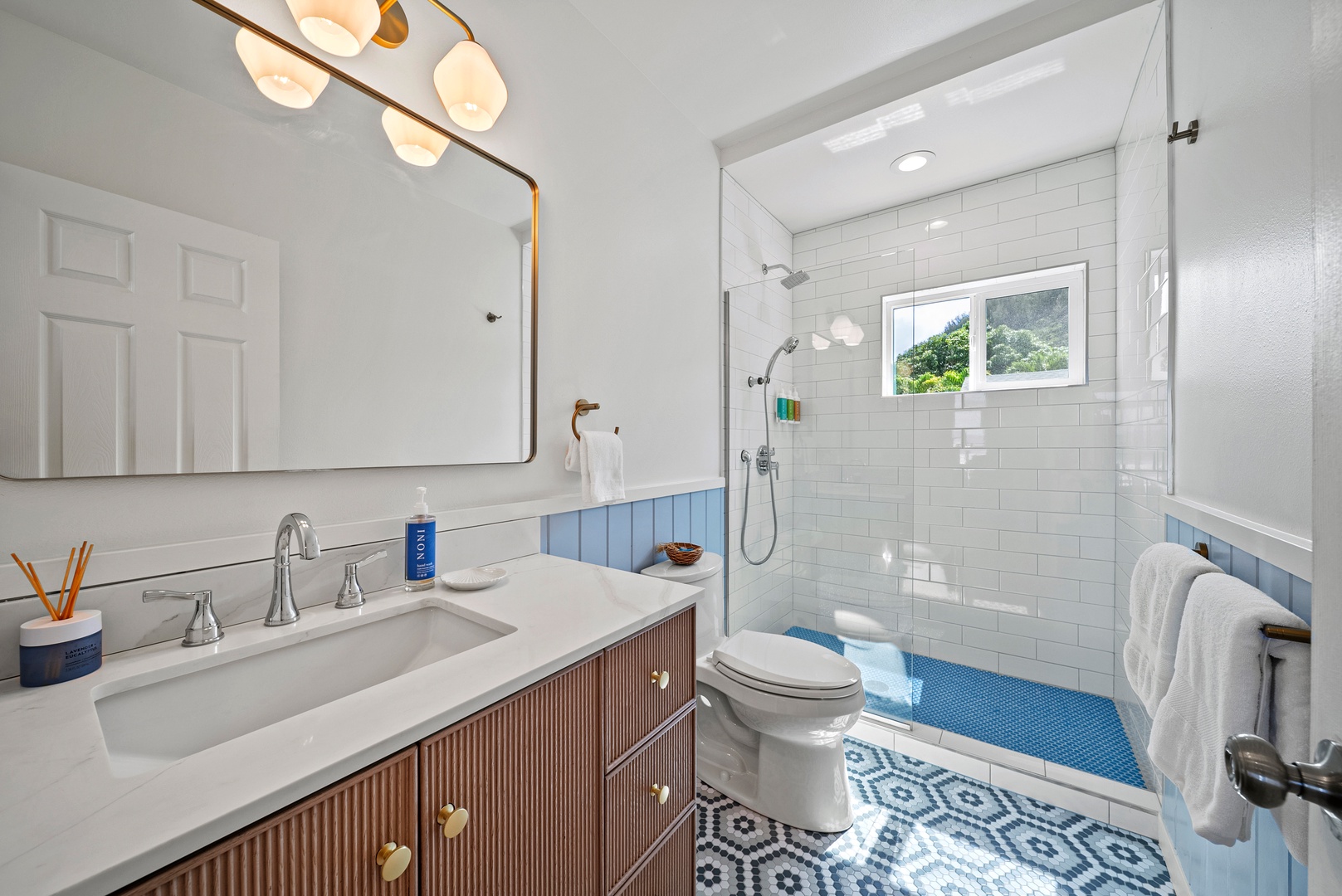 Haleiwa Vacation Rentals, Surfer's Paradise - Freshly updated bathroom featuring modern fixtures, spacious vanity, and a walk-in shower for easy post-beach refreshes. Sofa opens to queen bed