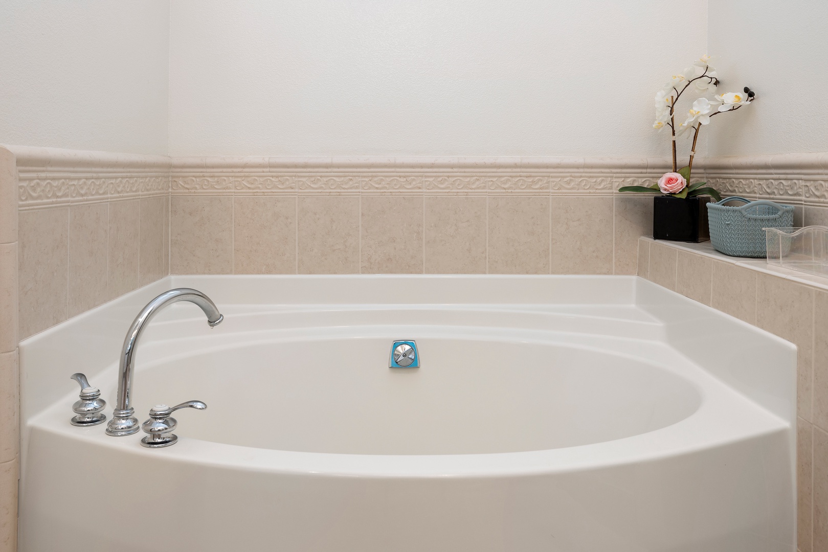 Sink into this luxurious soaking tub where elegant orchids and soft lighting create your perfect retreat for unwinding after exploring.