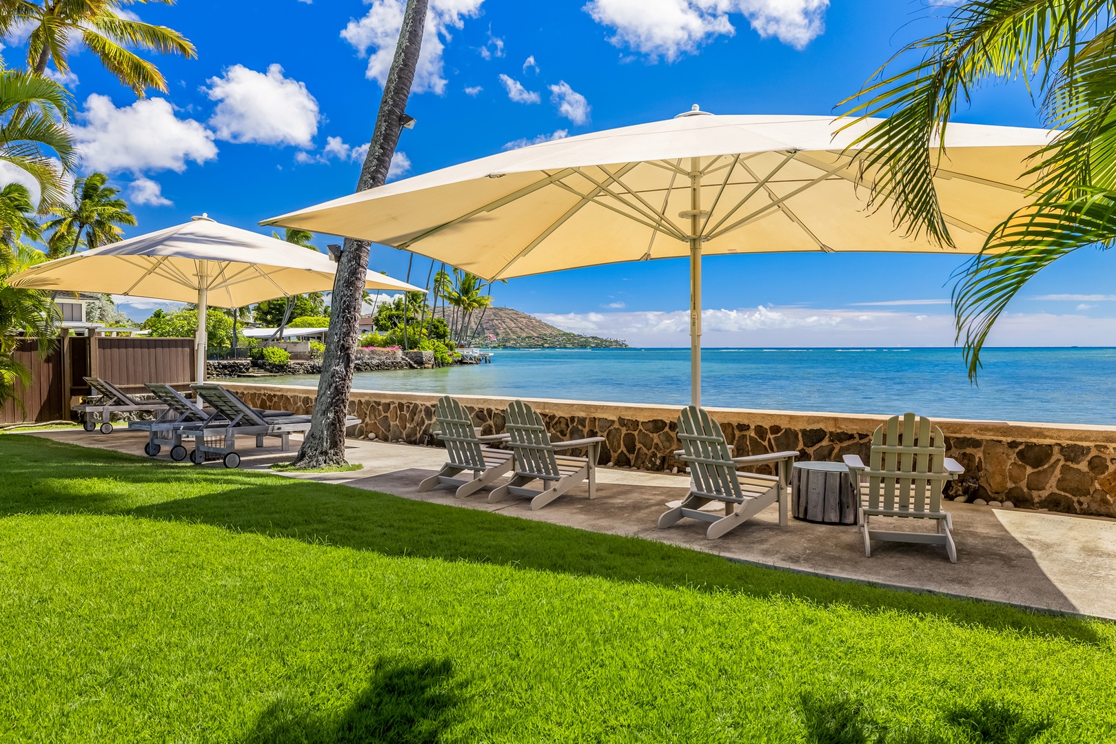 Honolulu Vacation Rentals, Moana Lani - Main House - Pick a spot in the shade under the big umbrellas, right where the lawn meets the water.