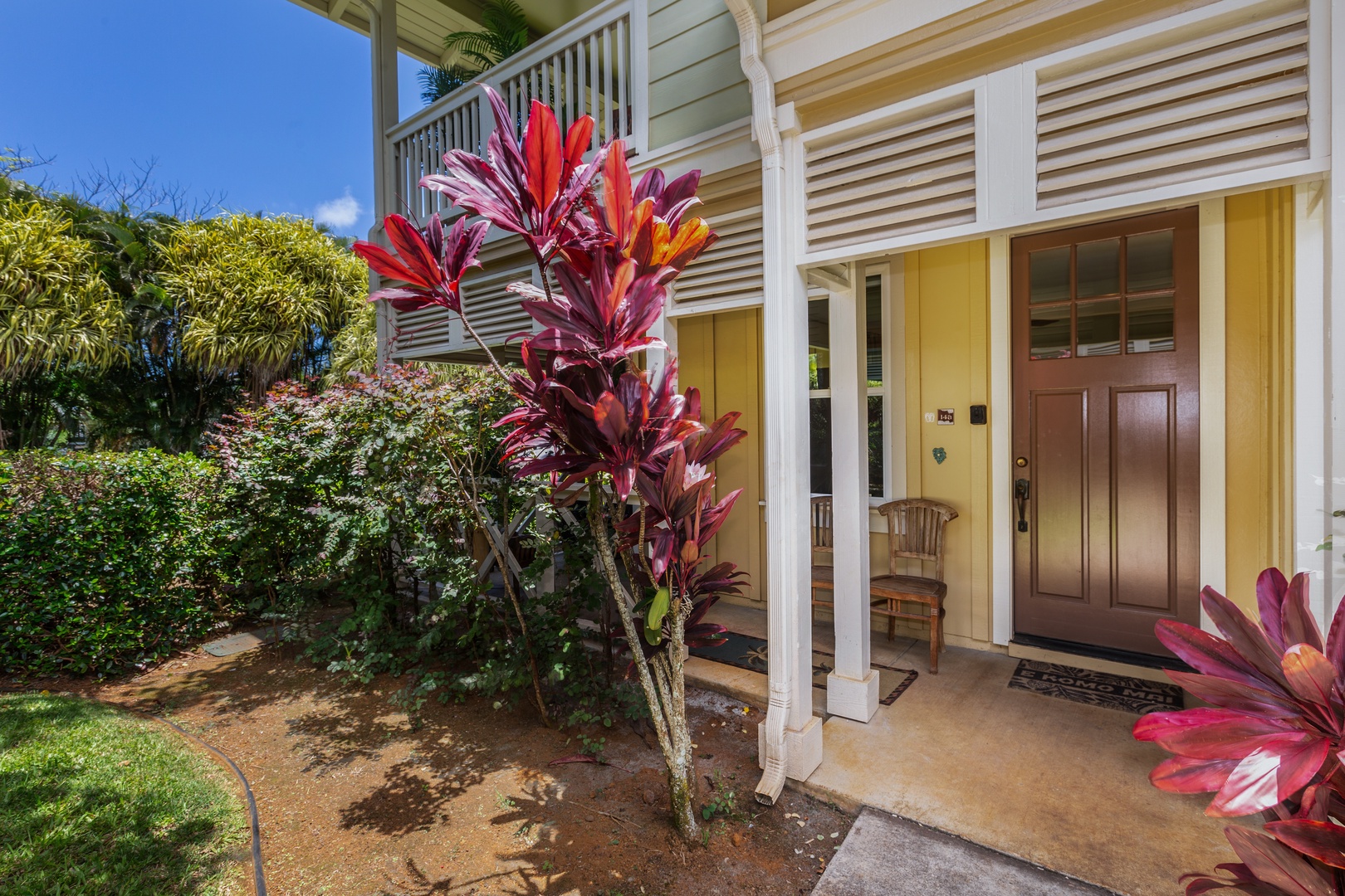 Princeville Vacation Rentals, Pualani Villa - The entrance is framed by vibrant tropical landscaping, creating a warm island welcome