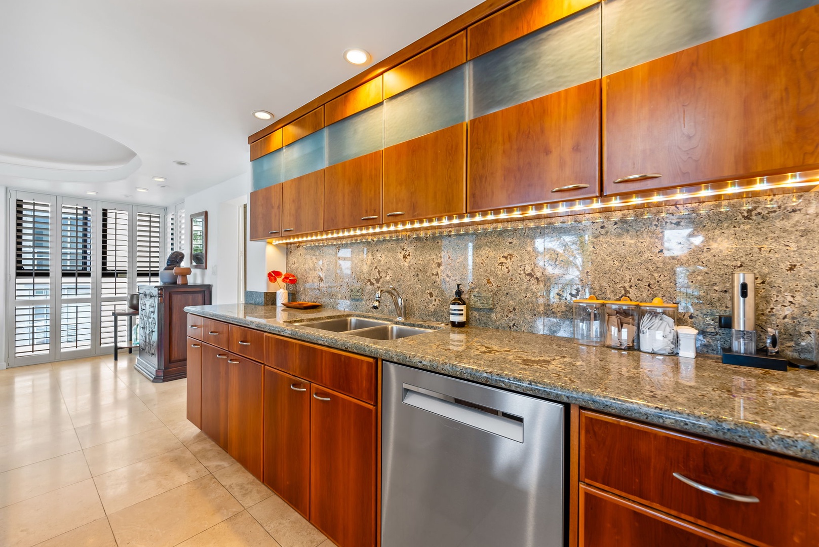 Honolulu Vacation Rentals, Kaimana Views - Stylish kitchen with rich wood cabinetry, stainless steel appliances, and elegant backsplash, perfect for preparing meals in style