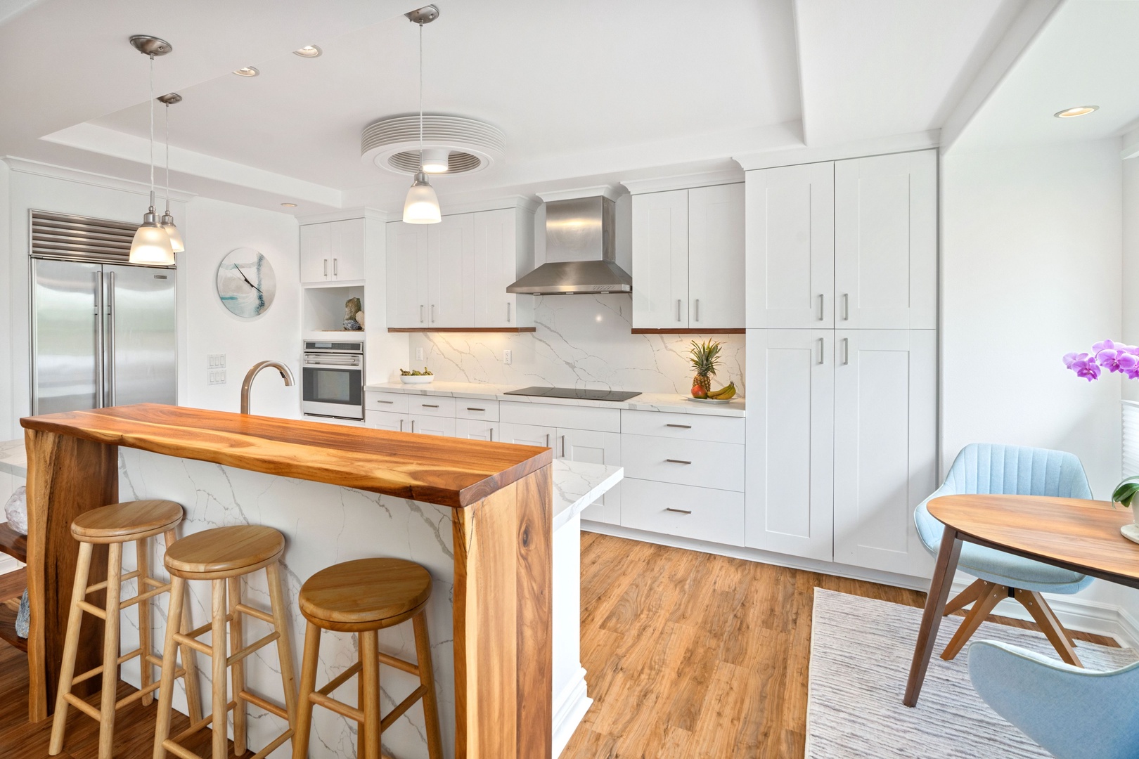 Princeville Vacation Rentals, Tropical Elegance - Experience a touch of luxury in this fully-equipped kitchen, featuring modern appliances, bar seating, and aesthetic decor, perfect for memorable short-term stays.