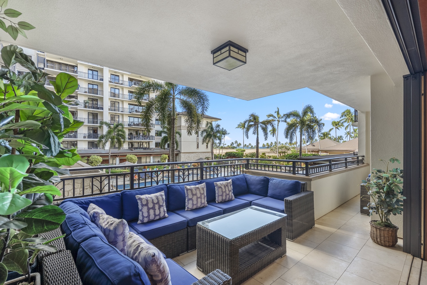 Kapolei Vacation Rentals, Ko Olina Beach Villas O211 - Room enough on the lanai for everyone to spread out, palms and the pool past the rail.